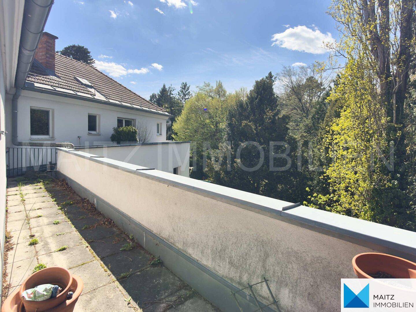 Weitläufiger Balkon mit weitem Blick ins Grüne und auf die umliegende Wohnbebauung.