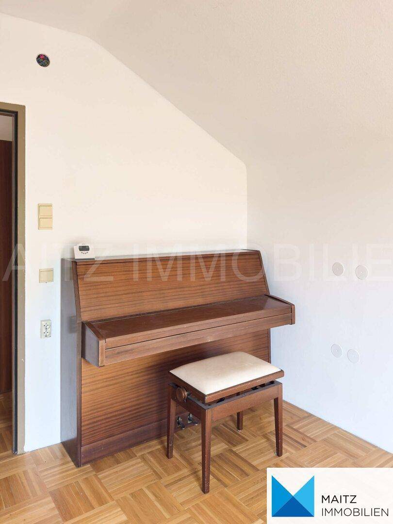 Gemütliches Zimmer mit Parkettboden und einem Klavier, ideal als Arbeits- oder Hobbyraum.