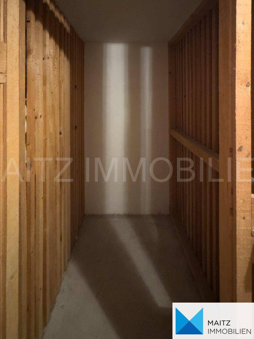 Kellerabteil mit Holzabtrennungen, bietet zusätzlichen Stauraum für Bewohner.