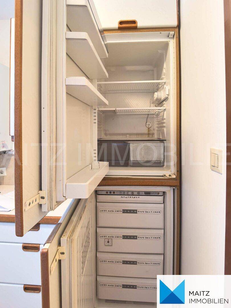 Integrierter Kühlschrank mit Gefrierfach, offen und bereit zur Befüllung.