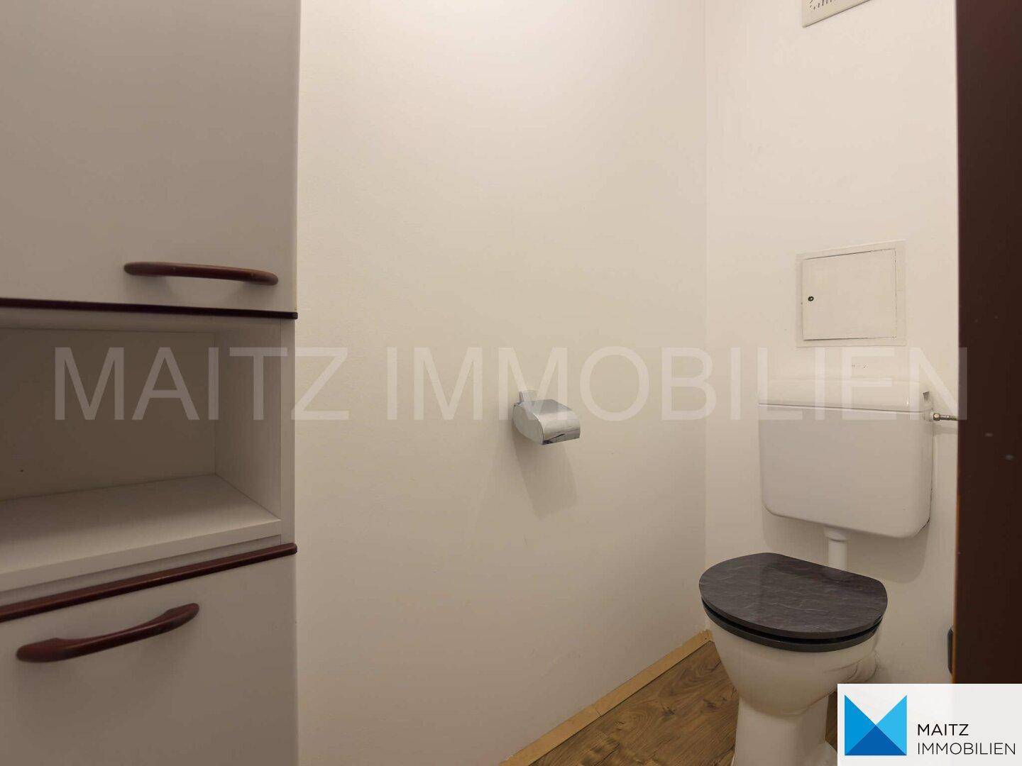 Separates WC mit Toilette und einfacher Ausstattung, funktional und sauber.