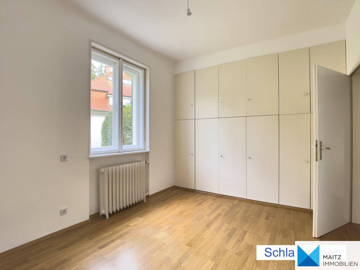 Schlafzimmer mit praktischen Einbauschränken und hellem Holzfußboden.