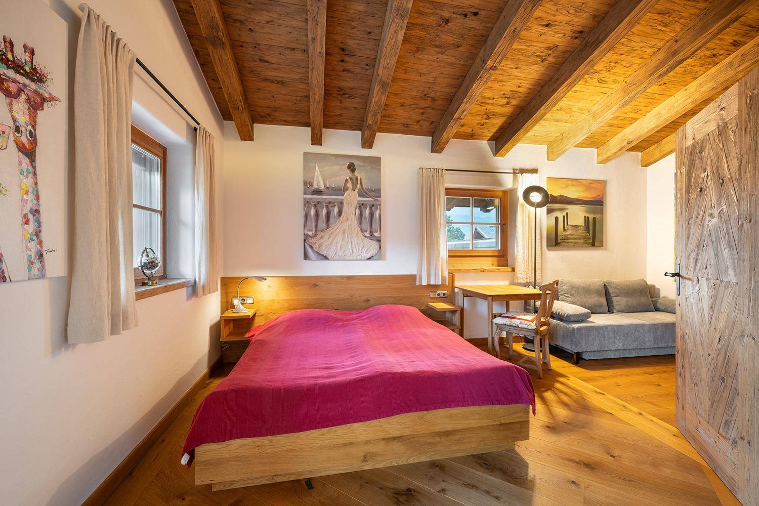 Gemütliches Schlafzimmer mit Holzbalkendecke, Holzboden und Doppelbett, hell und geräumig.