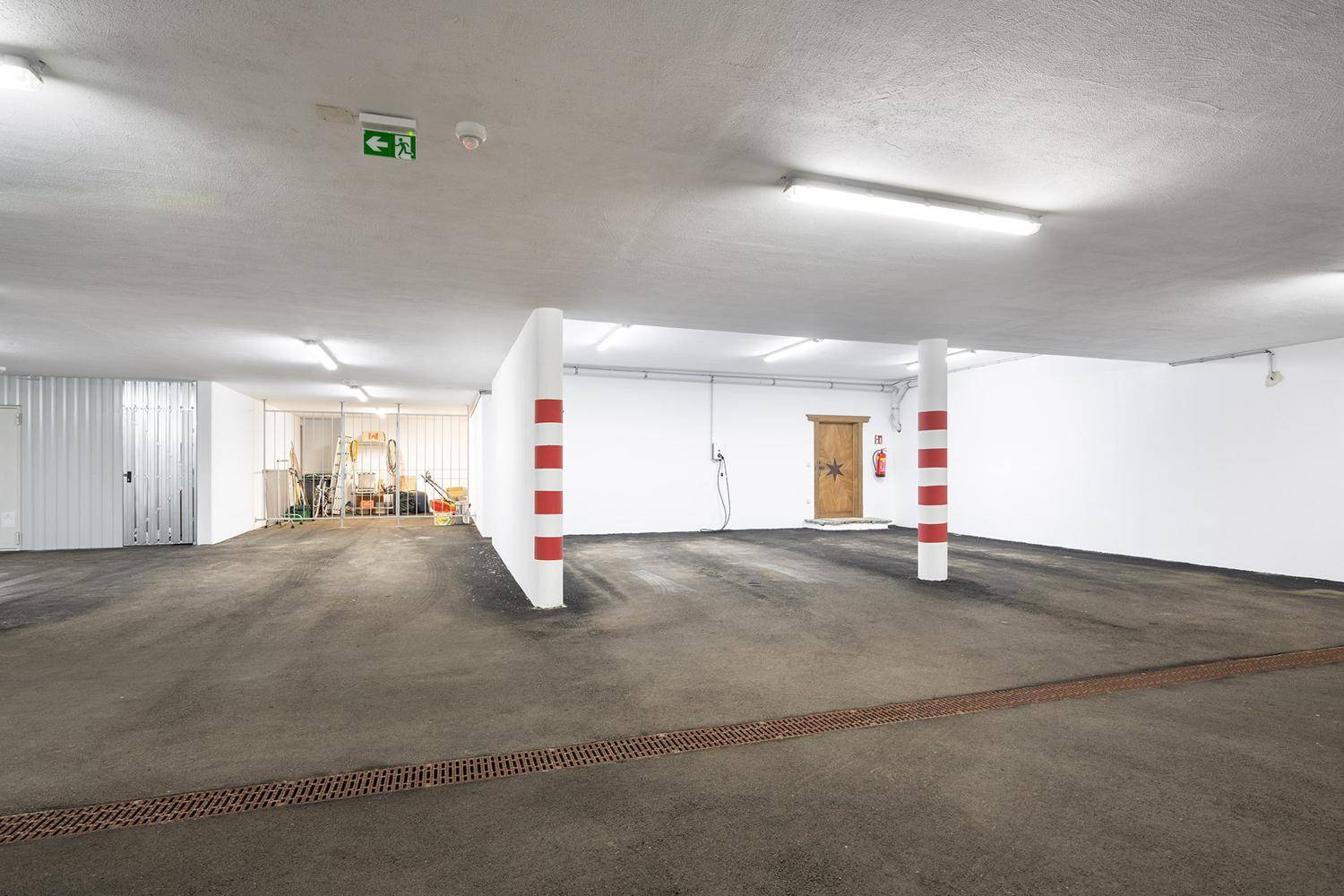 Geräumige Tiefgarage mit ausreichend Platz für mehrere Fahrzeuge und Lagerbereich.
