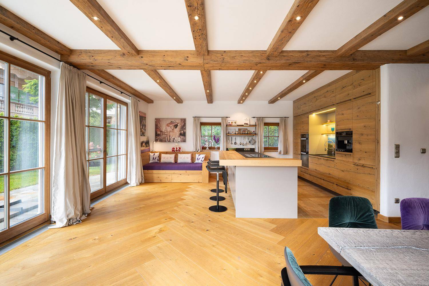 Helle, moderne Holzküche mit Kücheninsel und großen Fenstern zum Garten.