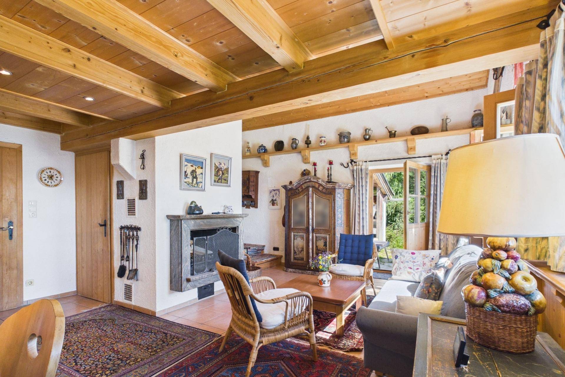 Wohnzimmer mit Kamin, traditionellen Möbeln und Zugang zum Außenbereich.