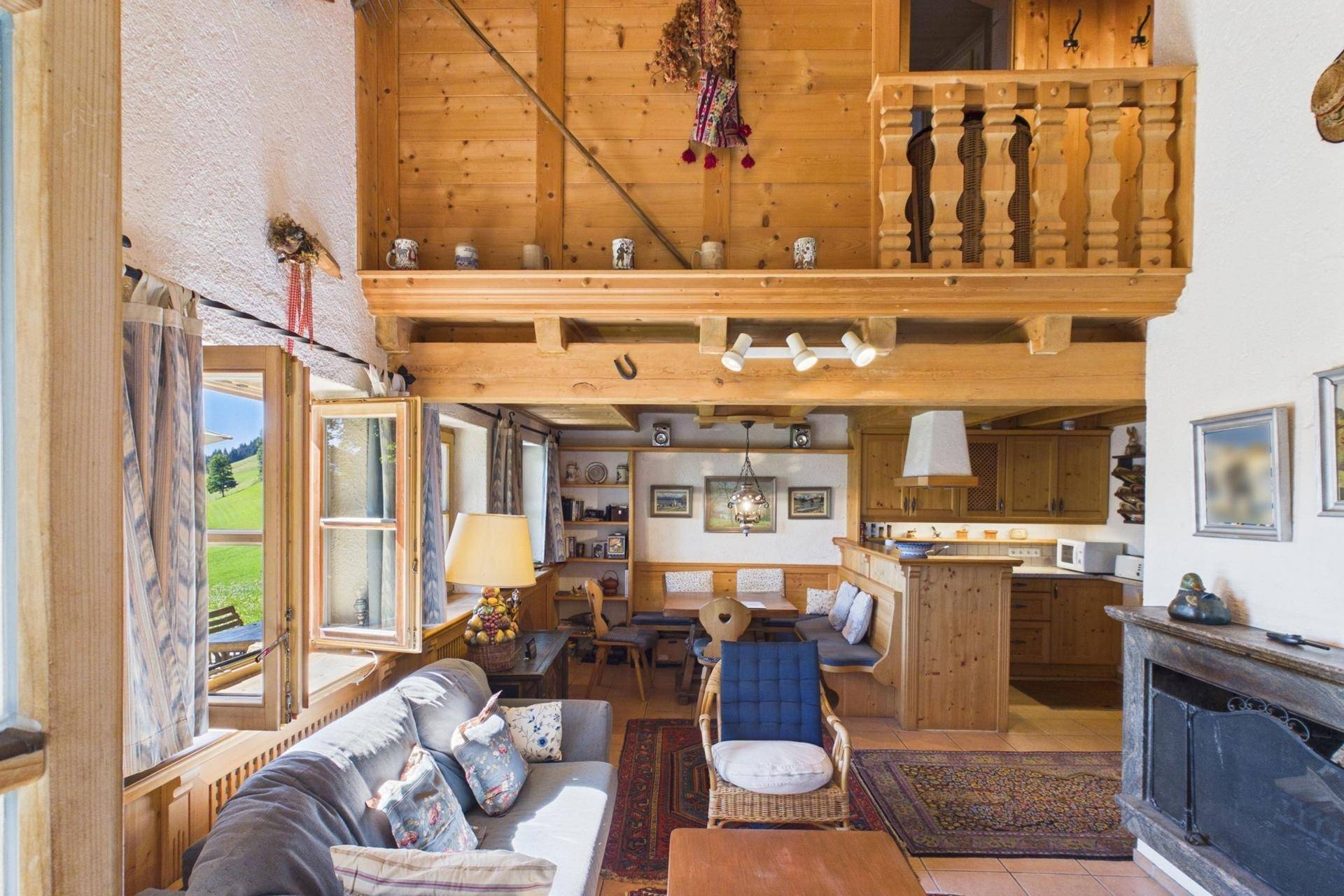 Gemütlicher Wohn-Essbereich im alpinen Stil mit offener Galerie und Holzbalkendecke.
