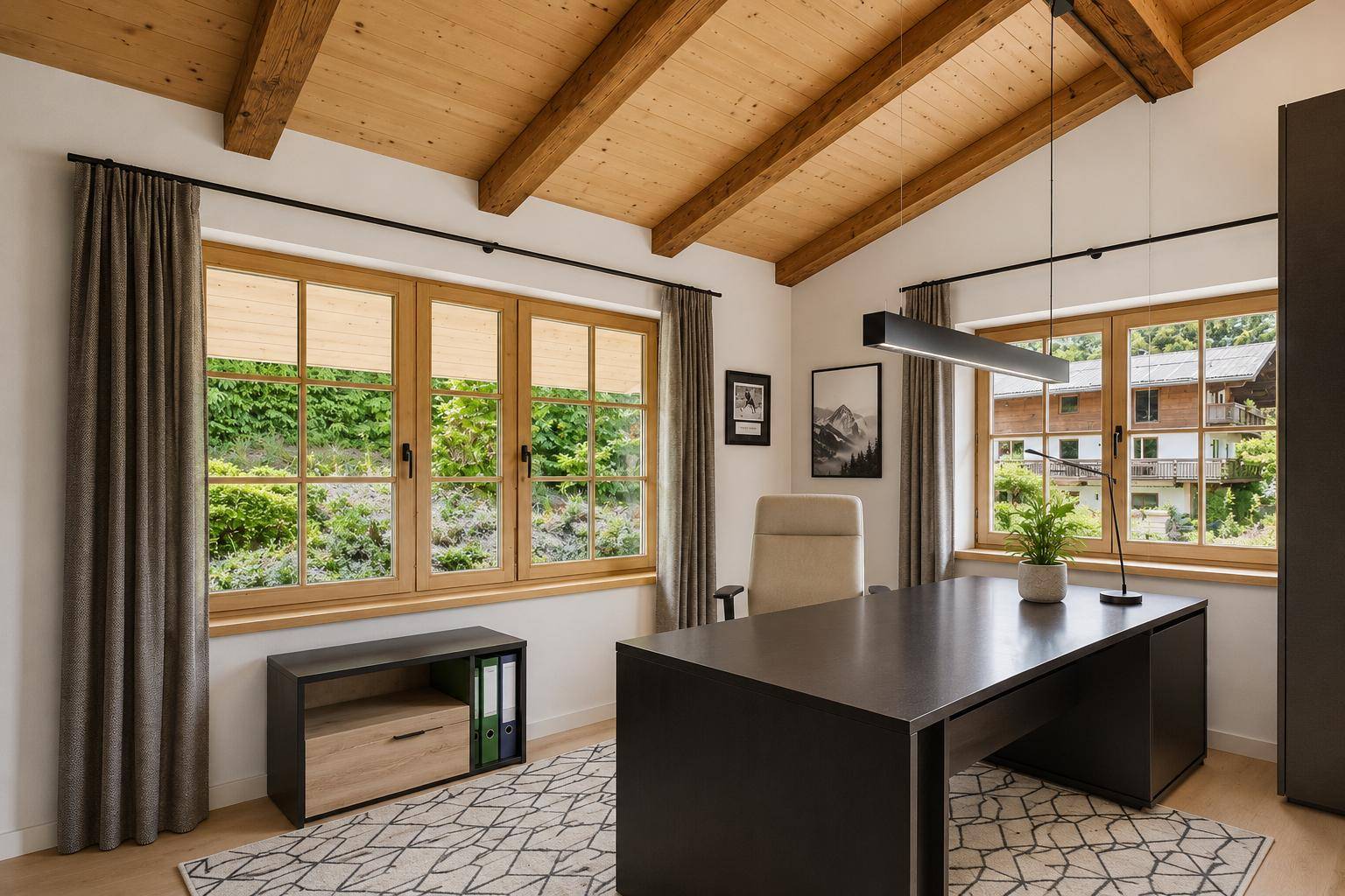 Helles Arbeitszimmer mit Holzbalkendecke, großem Schreibtisch und Blick ins Grüne.