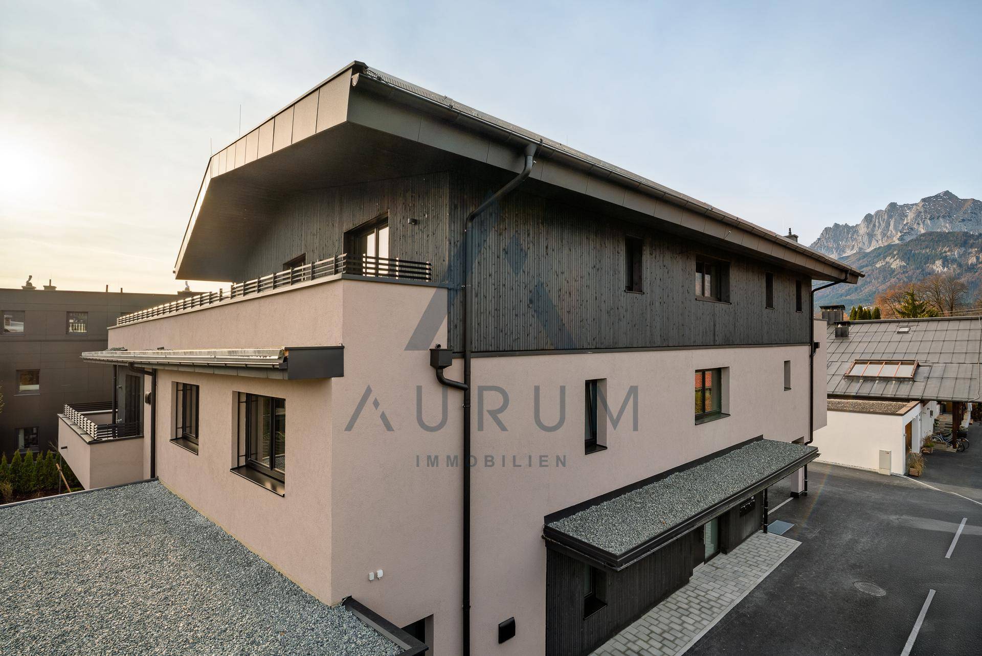 Moderne Architektur des Gebäudes mit dunkler Holzverkleidung und Bergblick im Hintergrund.