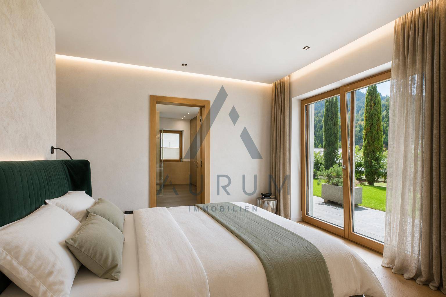 Helles Schlafzimmer mit großem Bett, indirekter Beleuchtung und Zugang zum Garten.