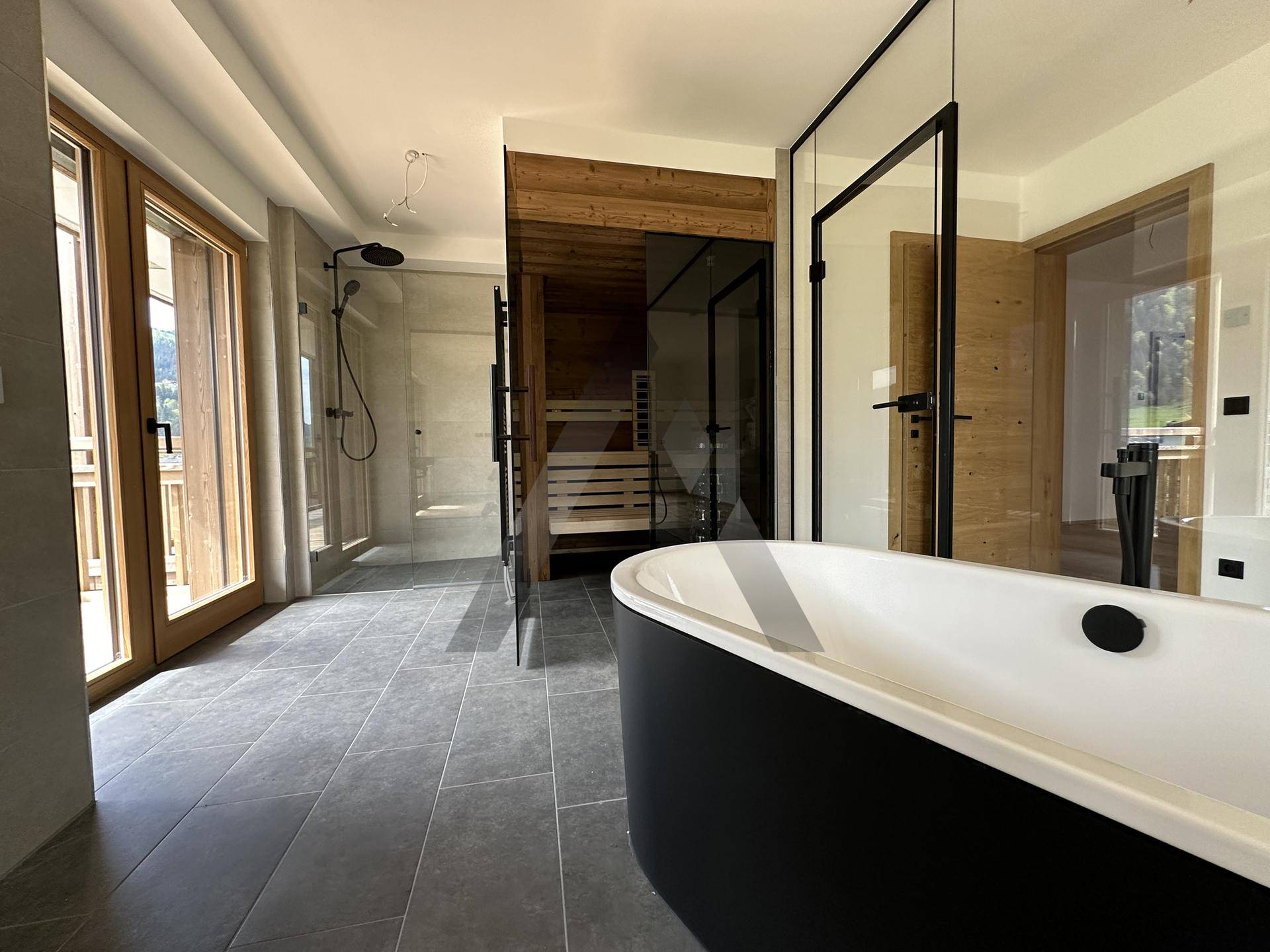 Exklusives Spa-Badezimmer mit freistehender Badewanne, großer Dusche und integrierter Sauna.