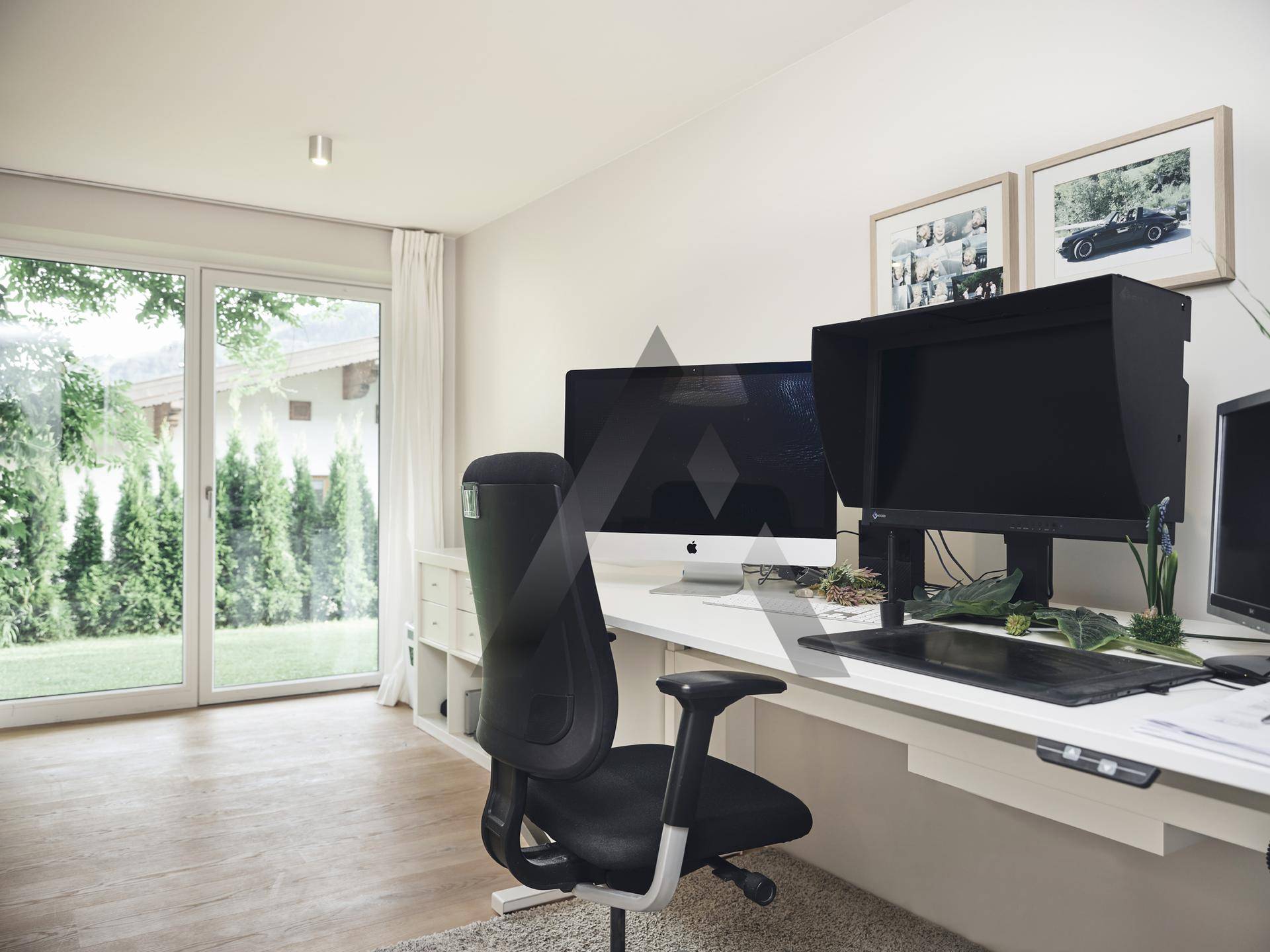 Helles Büro mit großem Fenster und direktem Zugang zum grünen Gartenbereich.