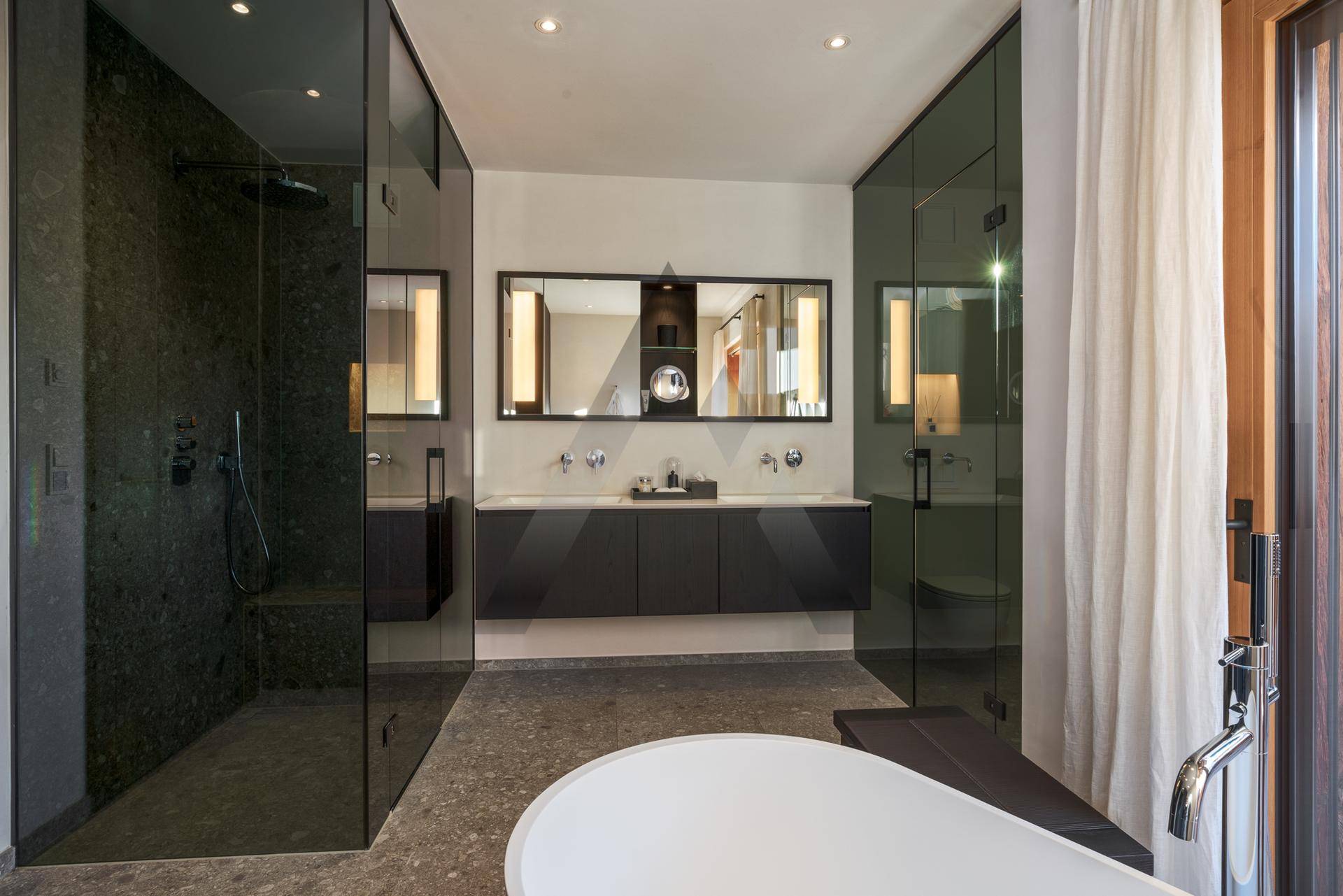 Modernes Badezimmer mit Doppelwaschbecken, großer Dusche und freistehender Badewanne.