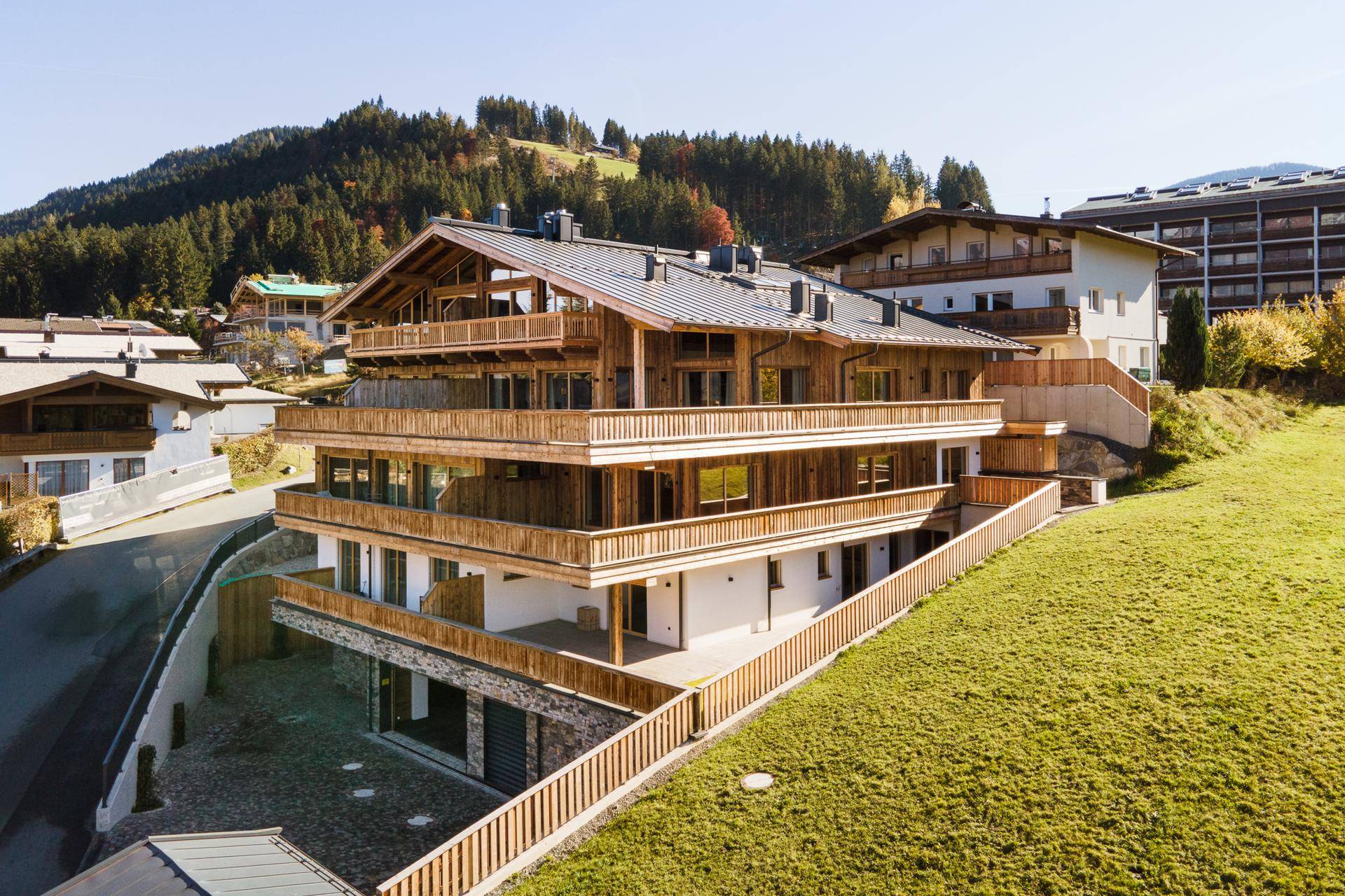 Großzügiges Holzchalet mit mehreren Balkonen und Terrassen, harmonisch in die Hanglage integriert.