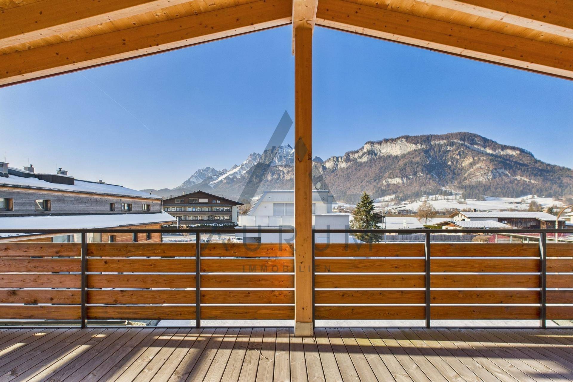 Geräumiger Holzbalkon mit Bergblick und sonniger Ausrichtung, ideal für entspannte Stunden im Freien.