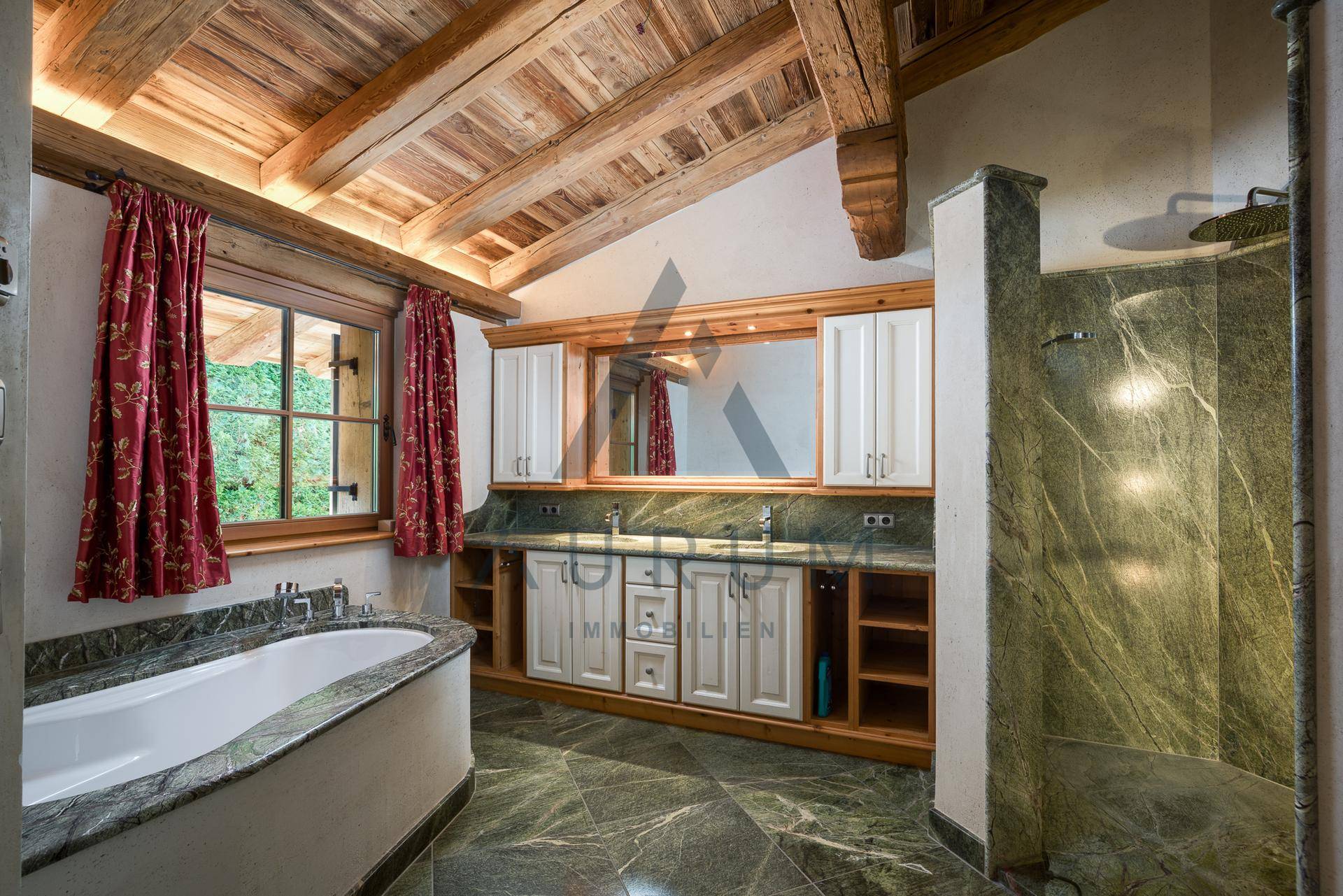 Elegantes Badezimmer mit Badewanne, Dusche und grünen Marmorfliesen.