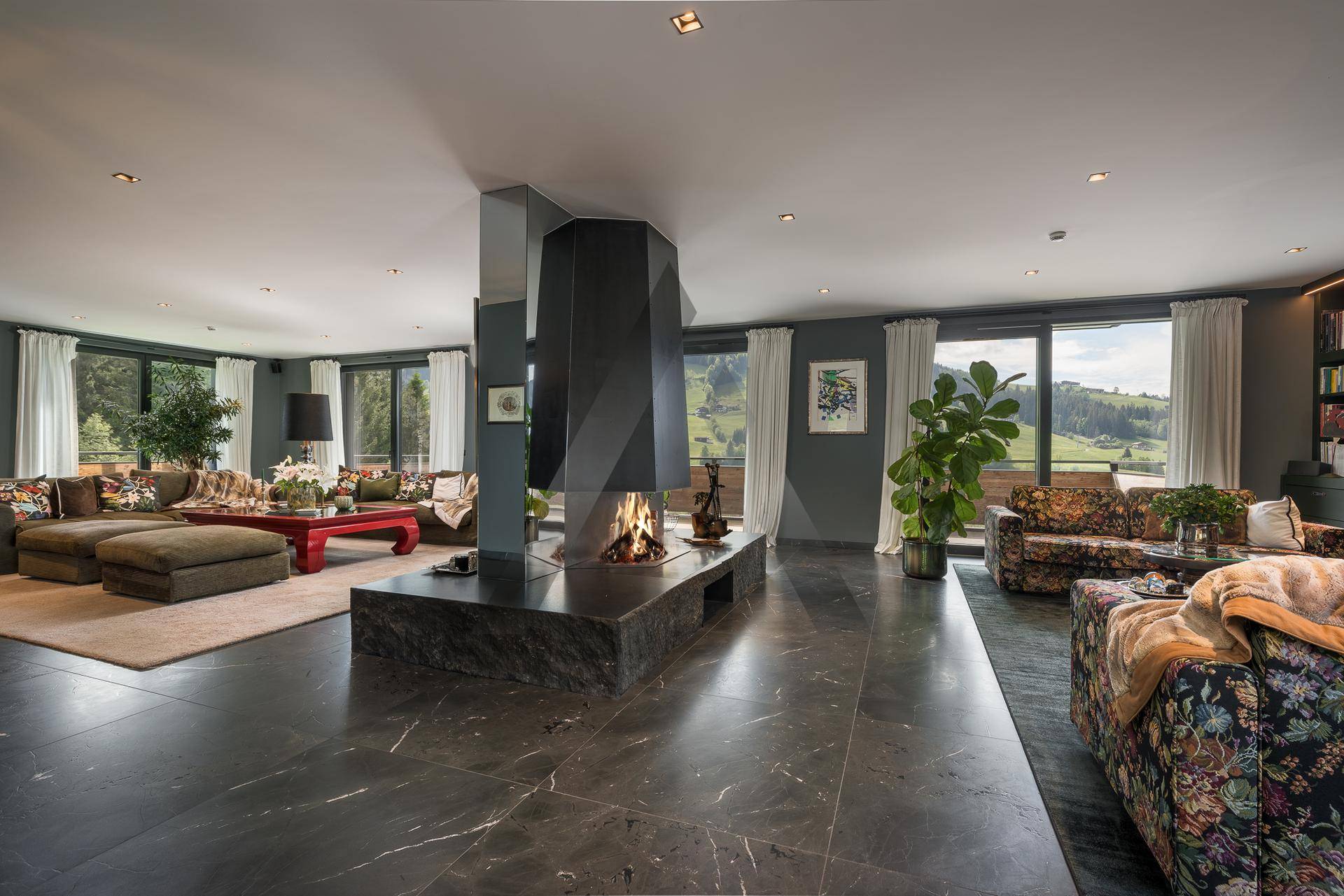 Großzügiges Wohnzimmer mit modernem Kamin als Mittelpunkt und dunklem Marmorboden.