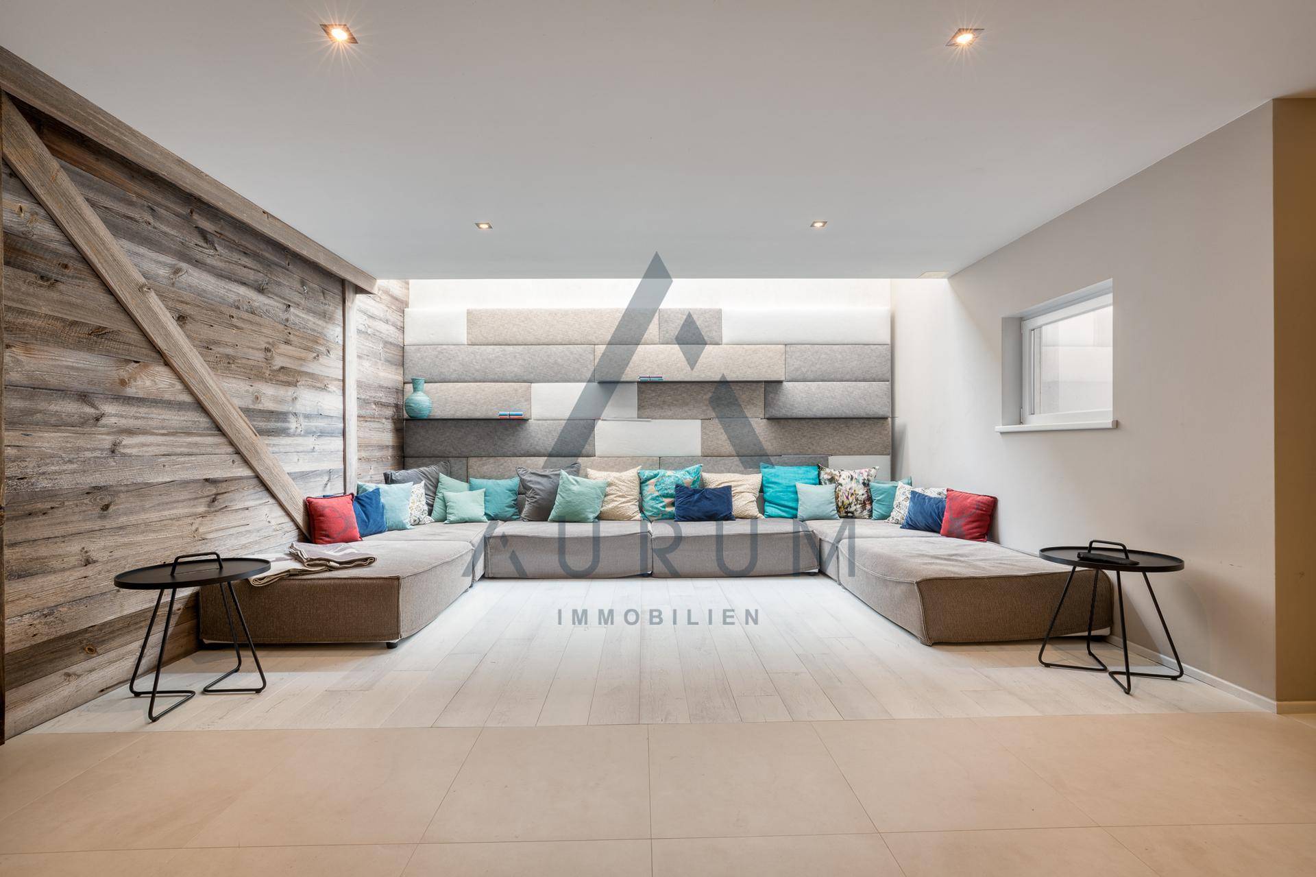 Gemütlicher Lounge-Bereich mit großem Sofa und dekorativer Wandgestaltung.