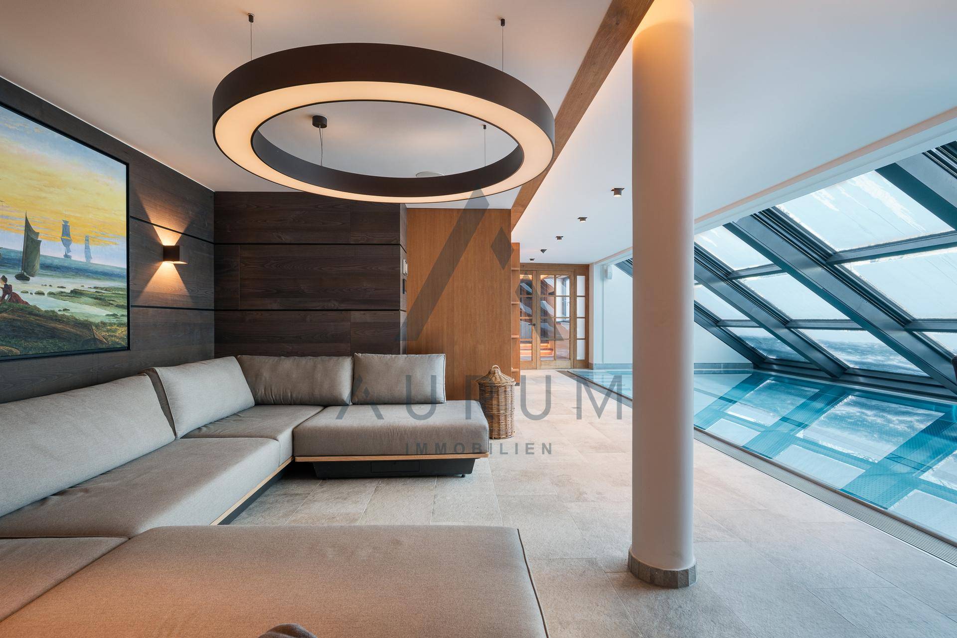 Gemütlicher Loungebereich neben dem Innenpool mit bequemen Sofas und moderner Beleuchtung.