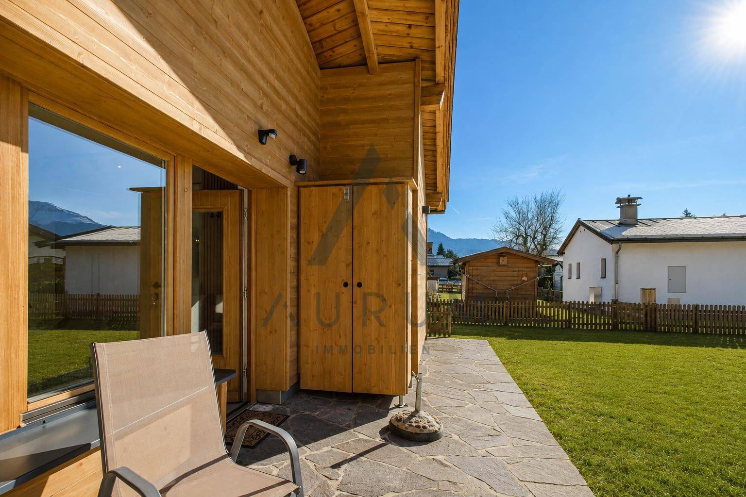 Gemütliche Terrasse am Holzhaus mit Sitzgelegenheiten und Blick ins Grüne.