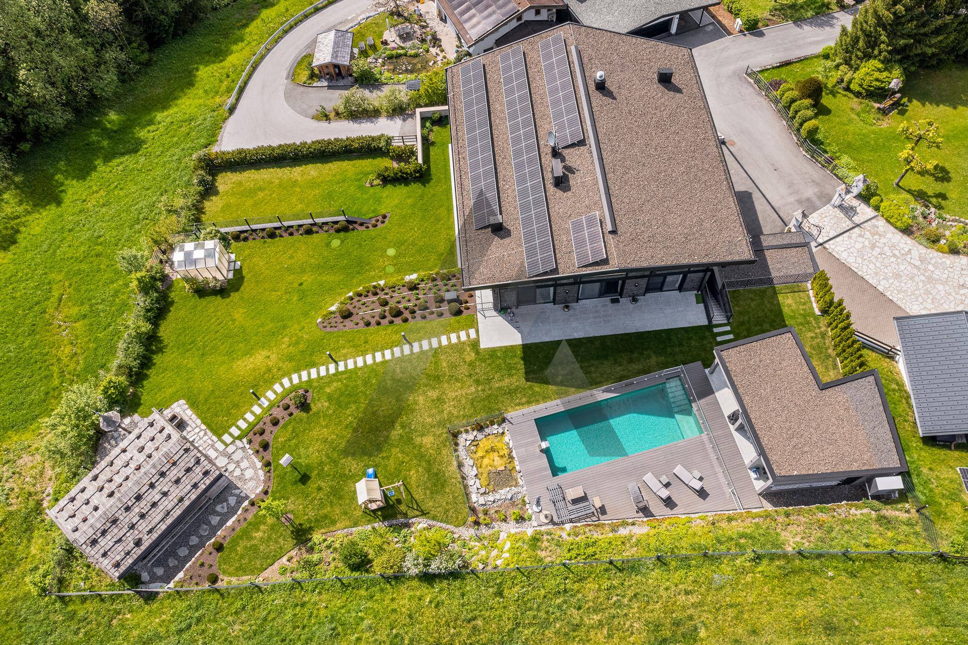 Luftaufnahme des Anwesens mit Pool, Garten, Photovoltaikanlage und umliegender Natur.