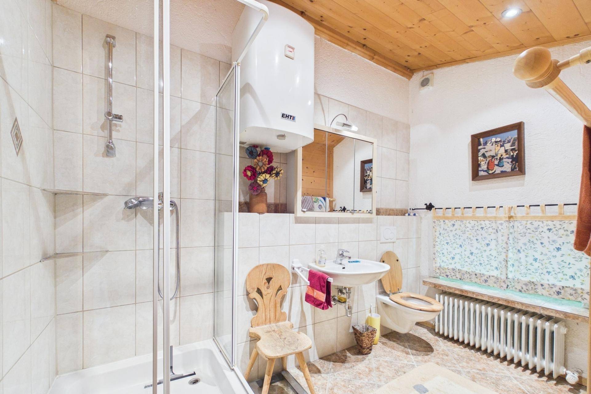 Badezimmer mit Dusche, WC und Waschbecken in traditionellem Design.