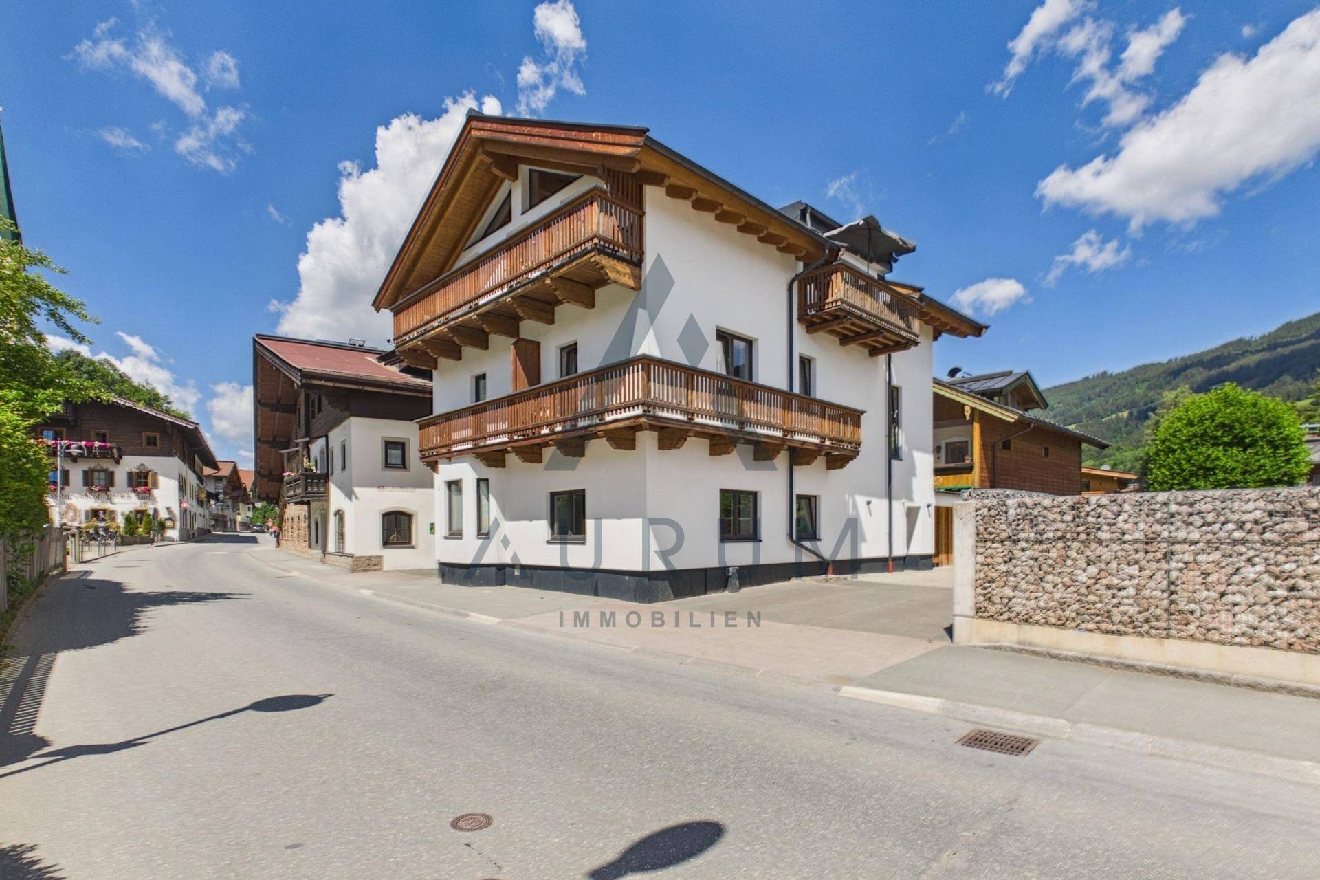 Attraktives Wohnhaus im alpinen Stil mit Holzbalkonen und gepflegter Fassade.