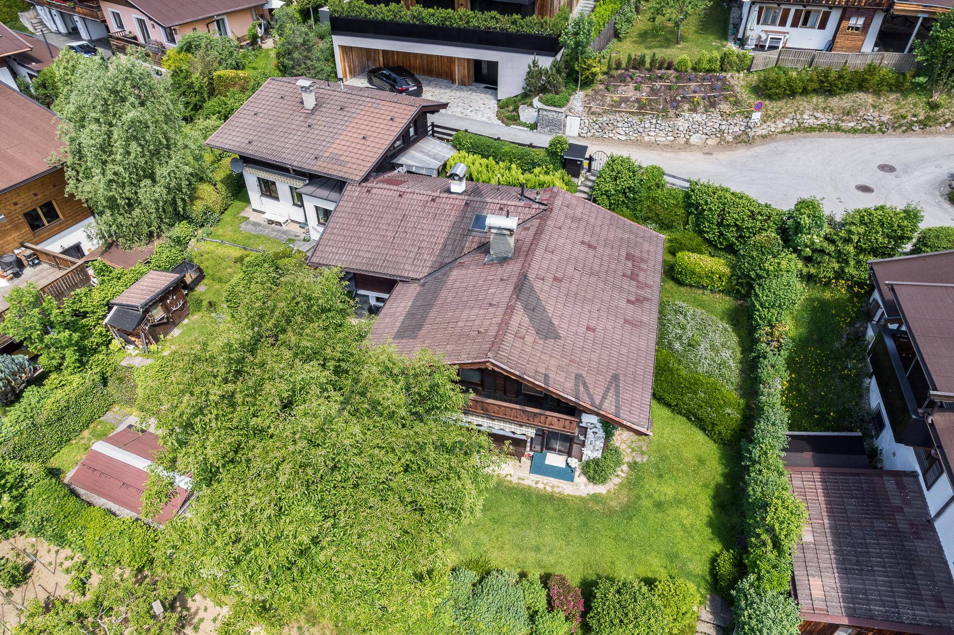 Vogelperspektive auf ein Wohnhaus mit weitläufigem Garten und angrenzenden Nachbargrundstücken.