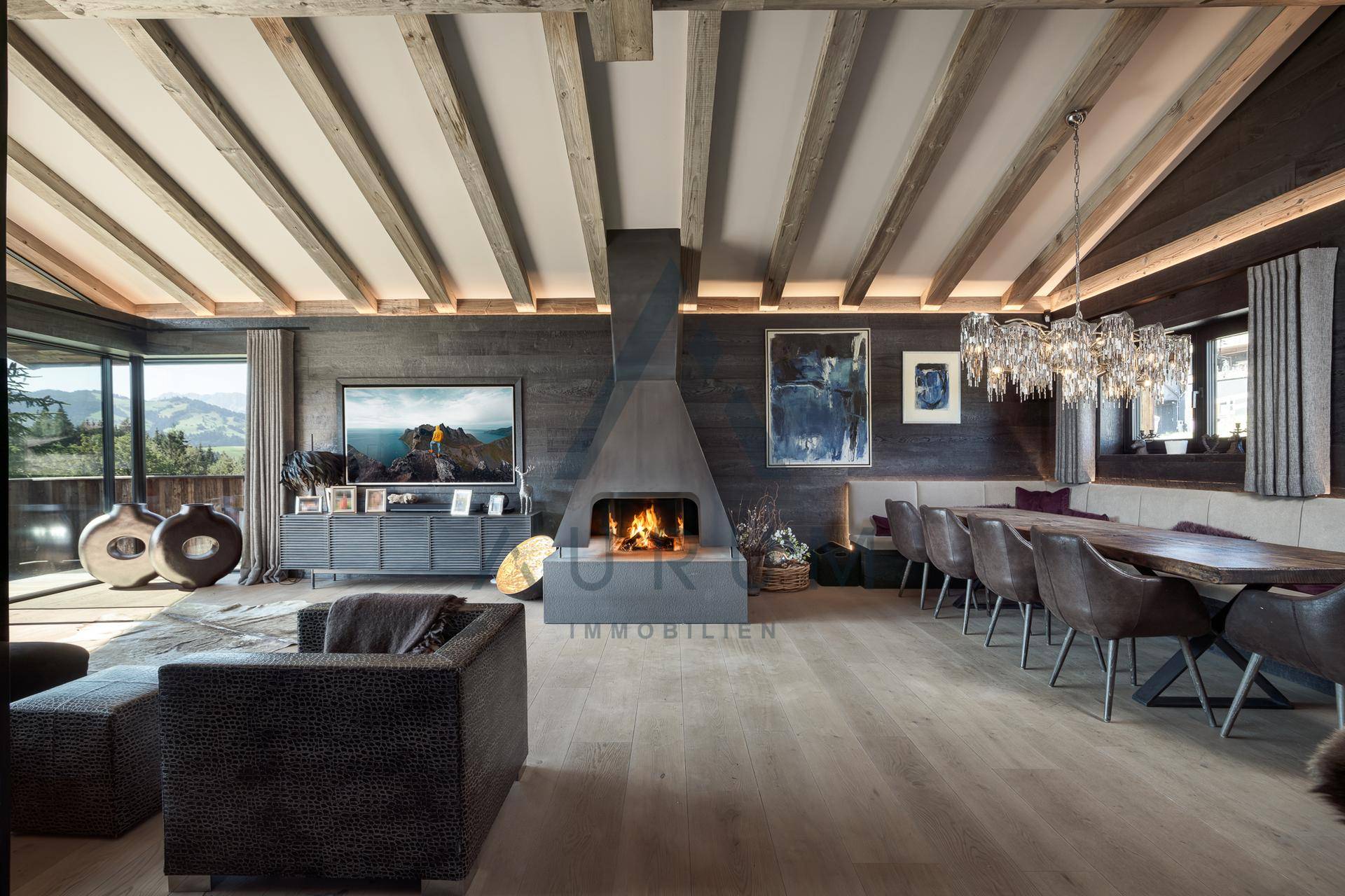 Eleganter Wohn- und Essbereich mit Kamin, Holzbalkendecke und großem Esstisch für gesellige Runden.