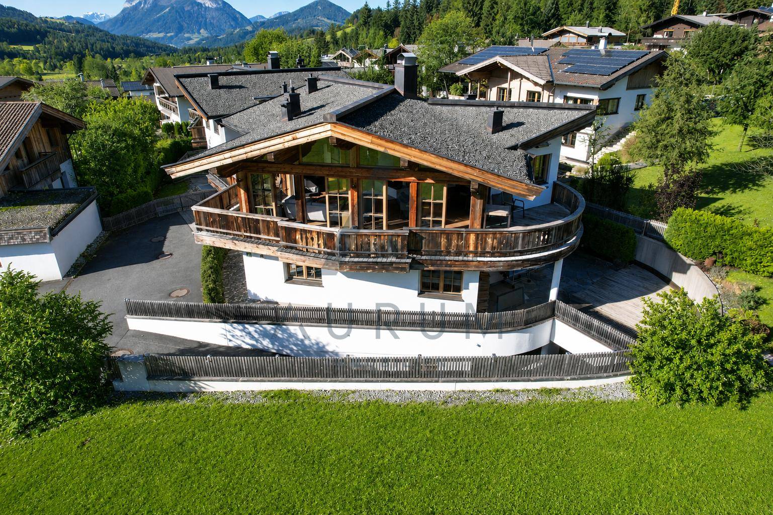 Alpines Chalet mit traditioneller Holzfassade und Balkonen in sonniger Lage.