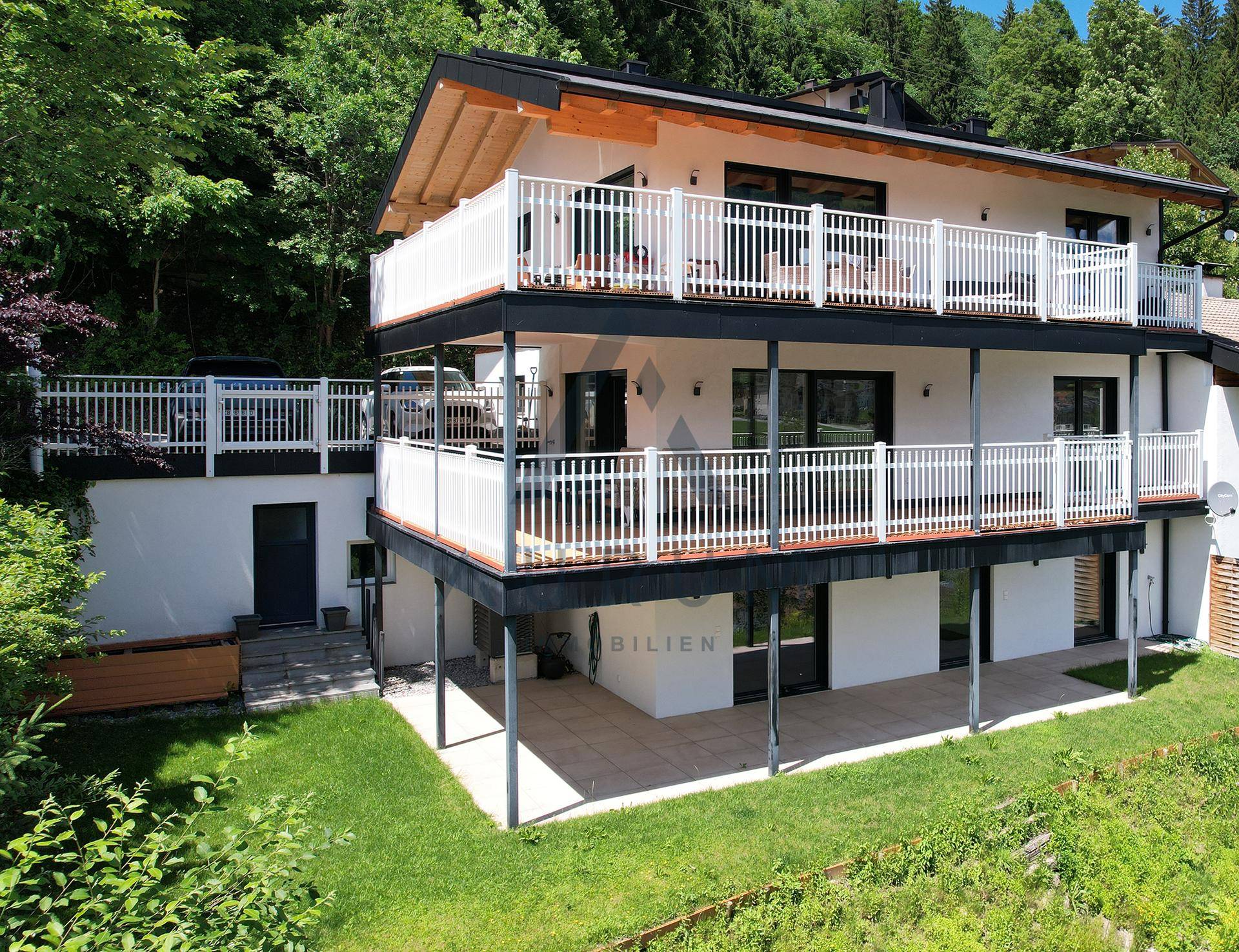 Attraktives Wohnhaus mit mehreren Balkonen und Terrassen, eingebettet in die Natur.