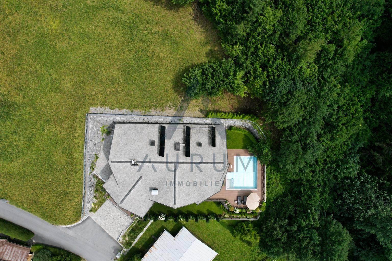 Luftaufnahme des gesamten Anwesens mit Haus, Pool und weitläufiger Grünfläche in der Natur.