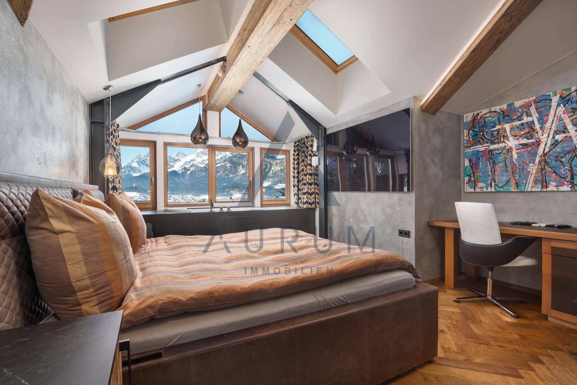 Schlafzimmer mit Dachschrägen, Holzbalken, großen Fenstern und beeindruckendem Bergblick.