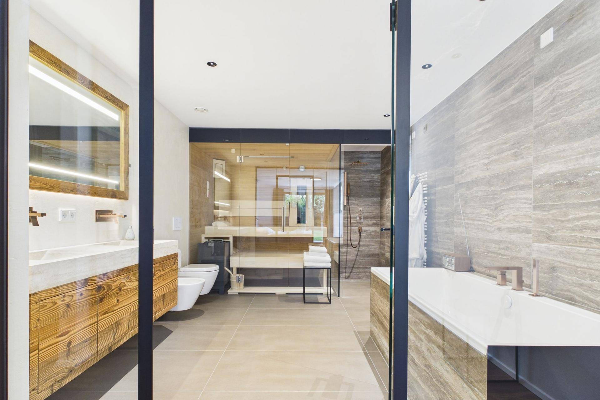 Großes, luxuriöses Badezimmer mit Badewanne, begehbarer Dusche und Doppelwaschbecken.