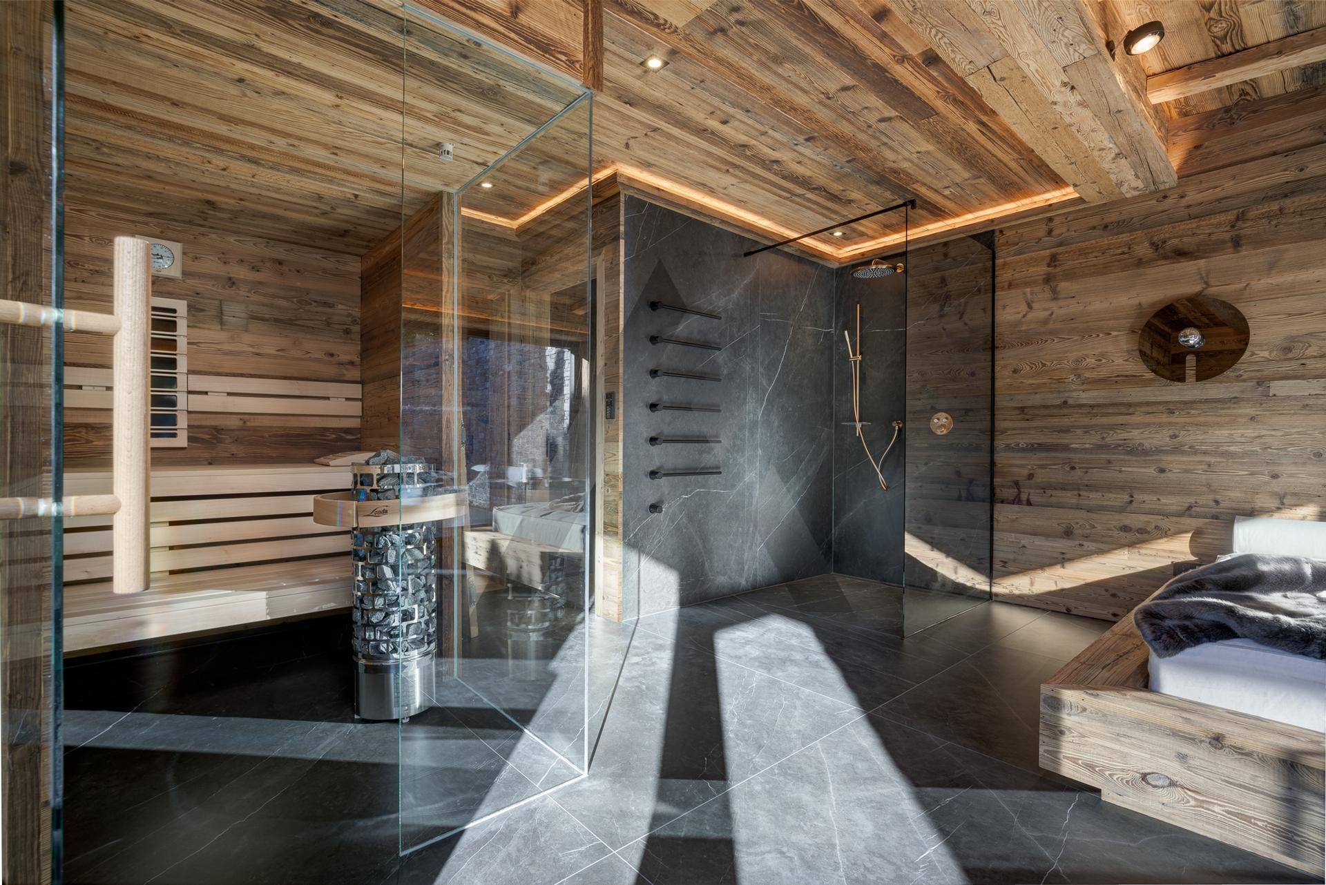 Luxuriöser Wellnessbereich mit Sauna, moderner Dusche und Holzelementen für pure Entspannung.