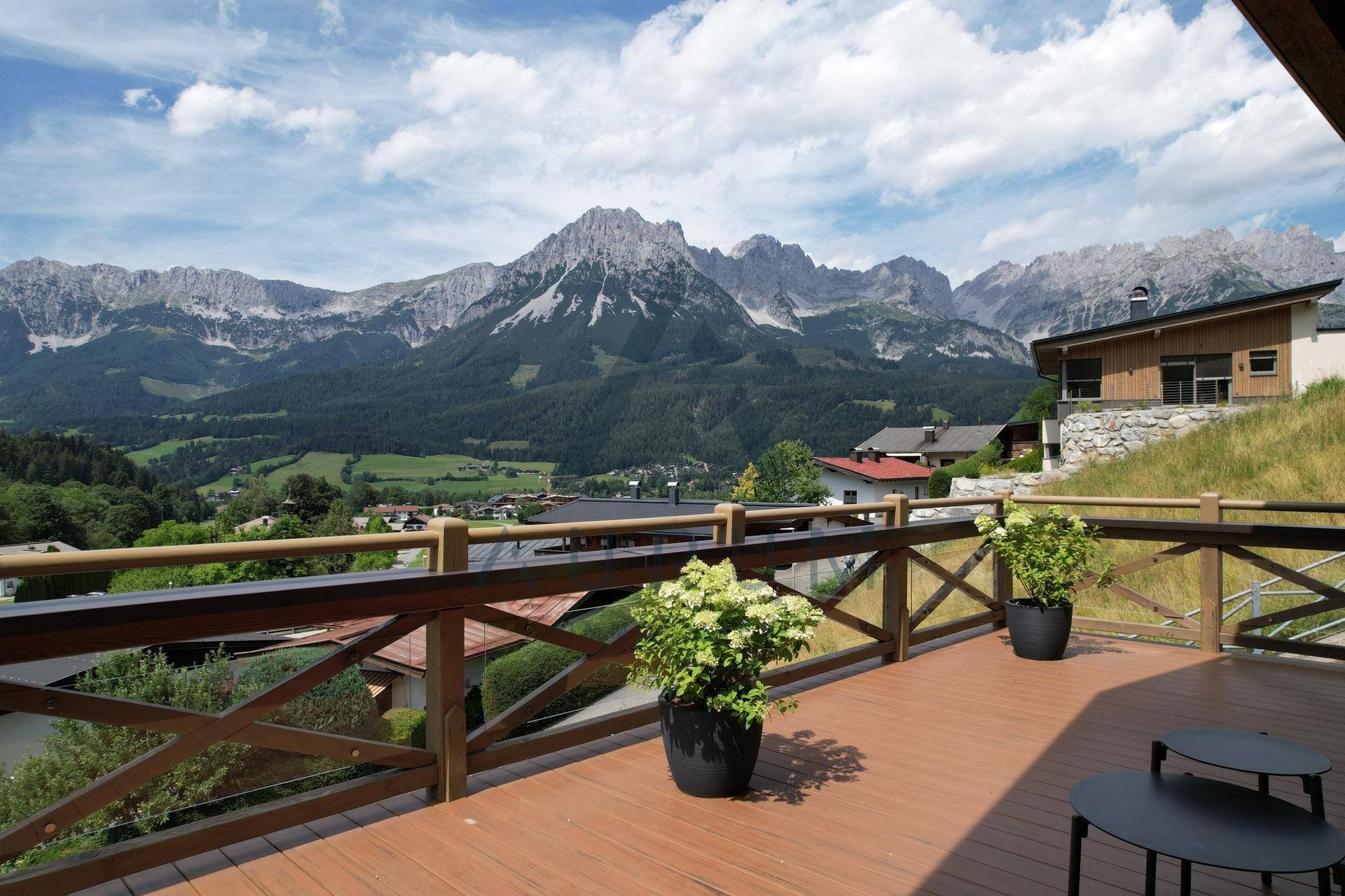 Geräumiger Balkon mit Holzboden und spektakulärem Panoramablick auf die umliegende Berglandschaft.