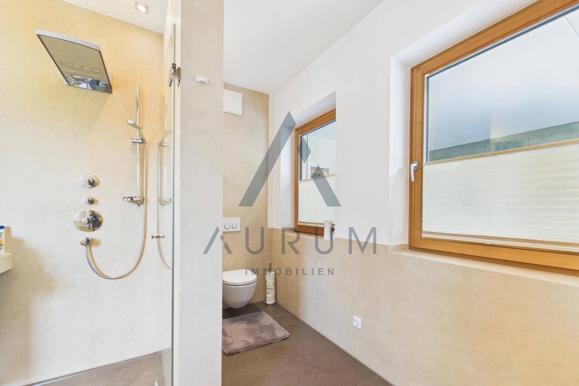 Modernes Badezimmer mit ebenerdiger Dusche, Wand-WC und Fenster für Tageslicht.