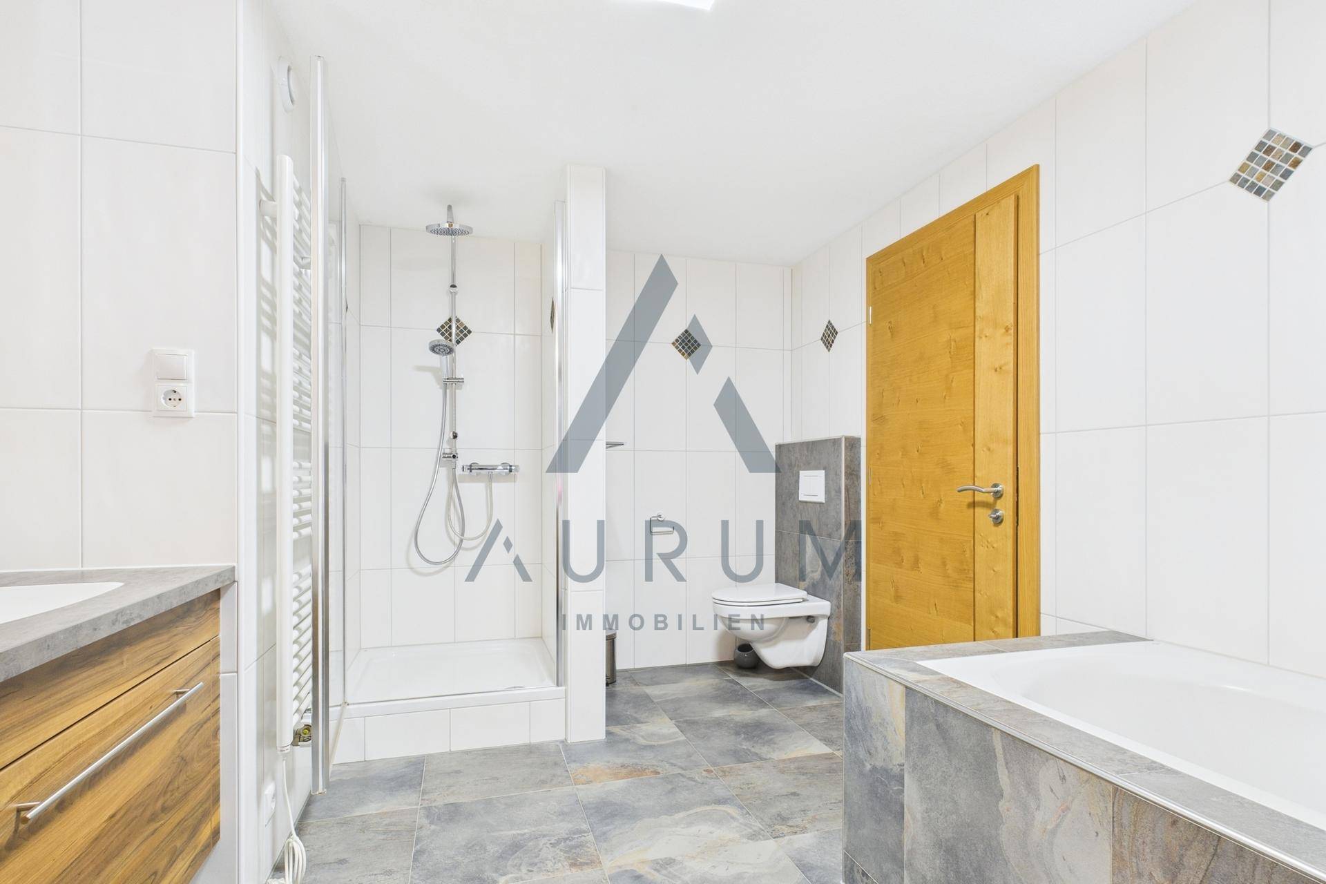 Modernes Badezimmer mit Dusche, Badewanne und wandhängender Toilette, ausgestattet mit Fliesenboden.
