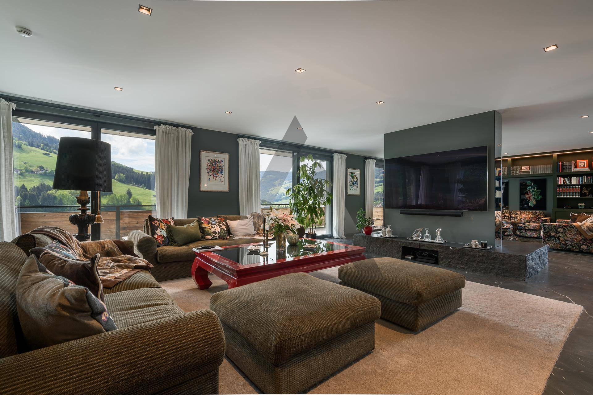 Gemütliches Wohnzimmer mit bequemen Sofas, großem Fernseher und Panoramablick.