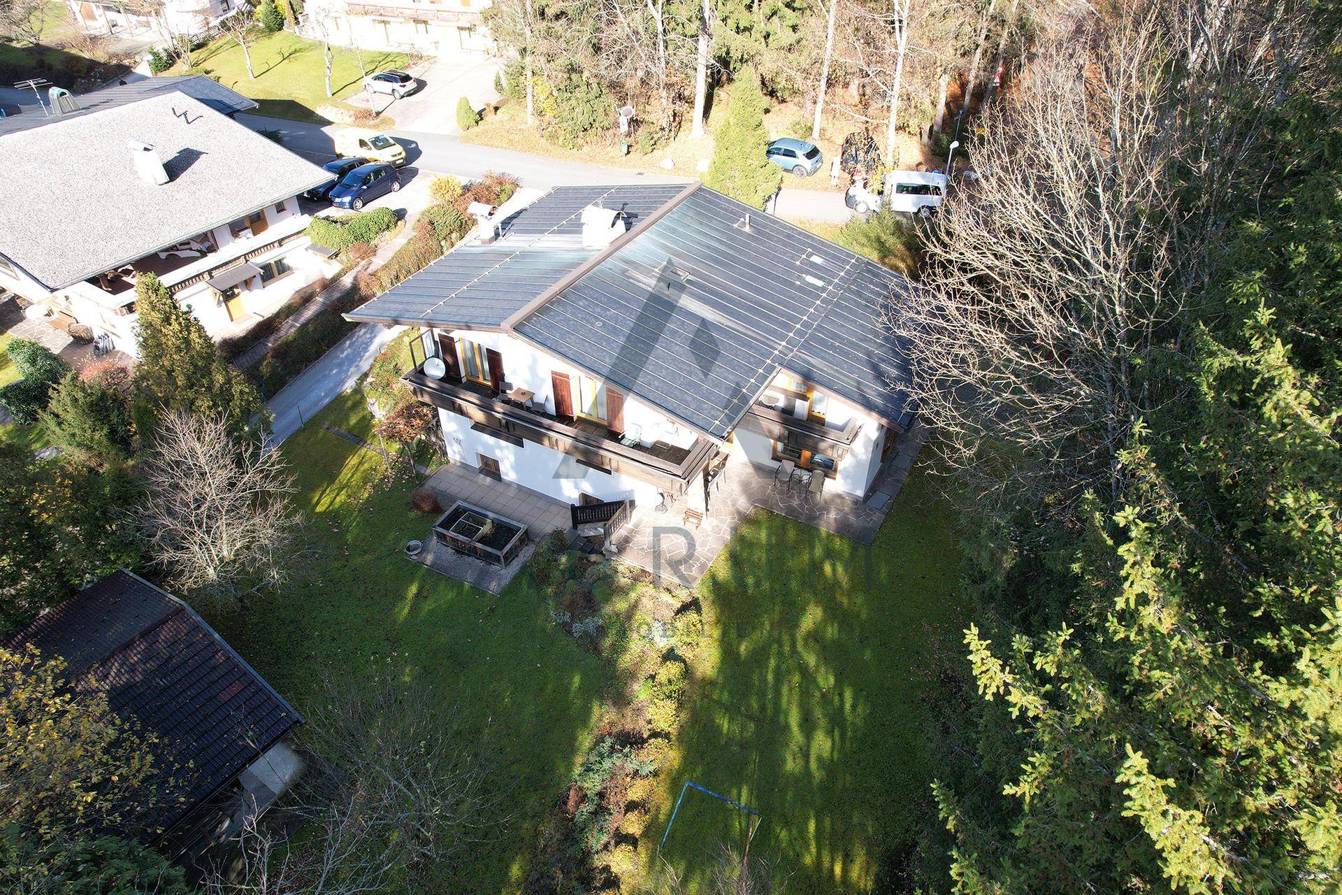Luftaufnahme eines Hauses mit Solaranlage auf dem Dach und großem Garten.