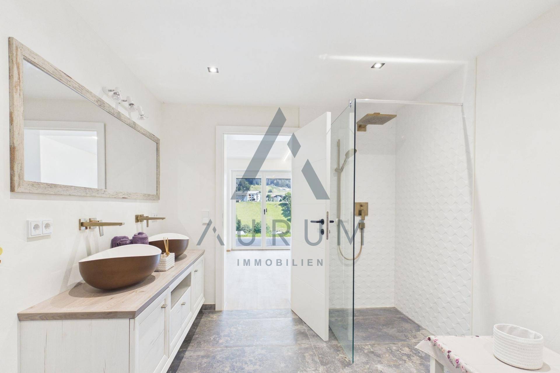 Geräumiges Badezimmer mit begehbarer Dusche, Doppelwaschbecken und großem Spiegel.