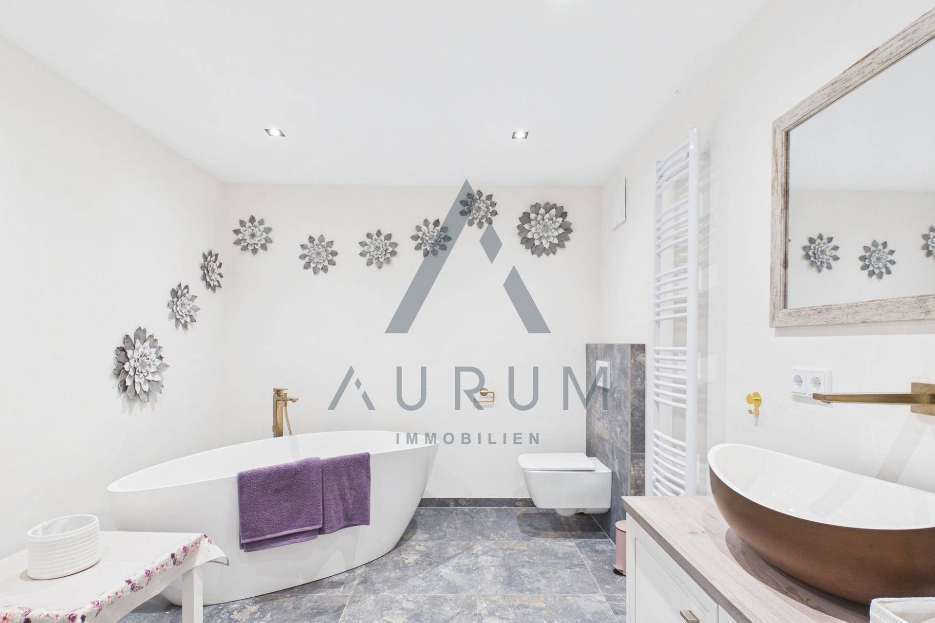 Modernes Badezimmer mit freistehender Badewanne, Doppelwaschbecken und beheiztem Handtuchhalter.