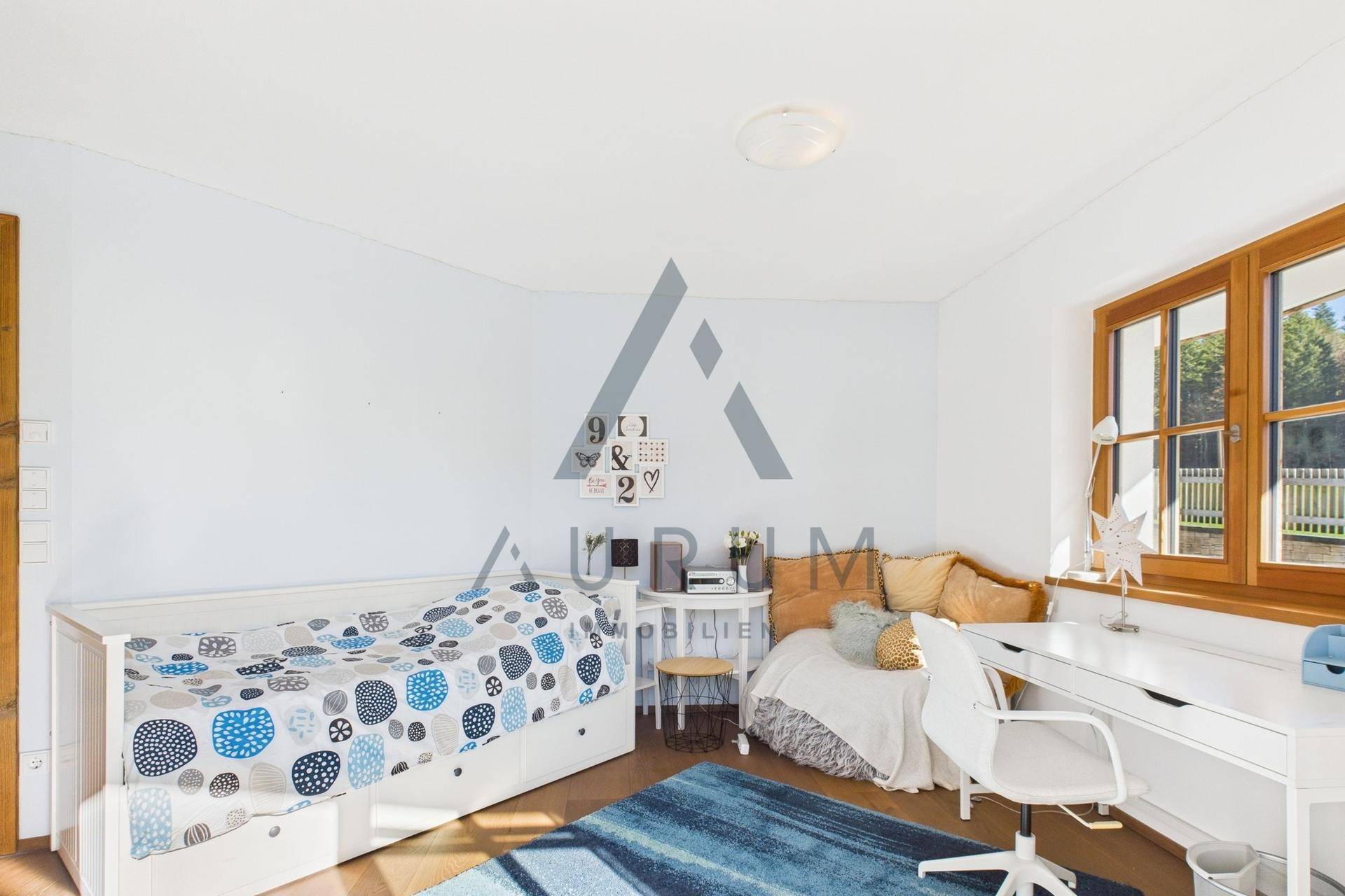 Freundliches Kinderzimmer mit zwei Betten, Holzboden und Fenster.