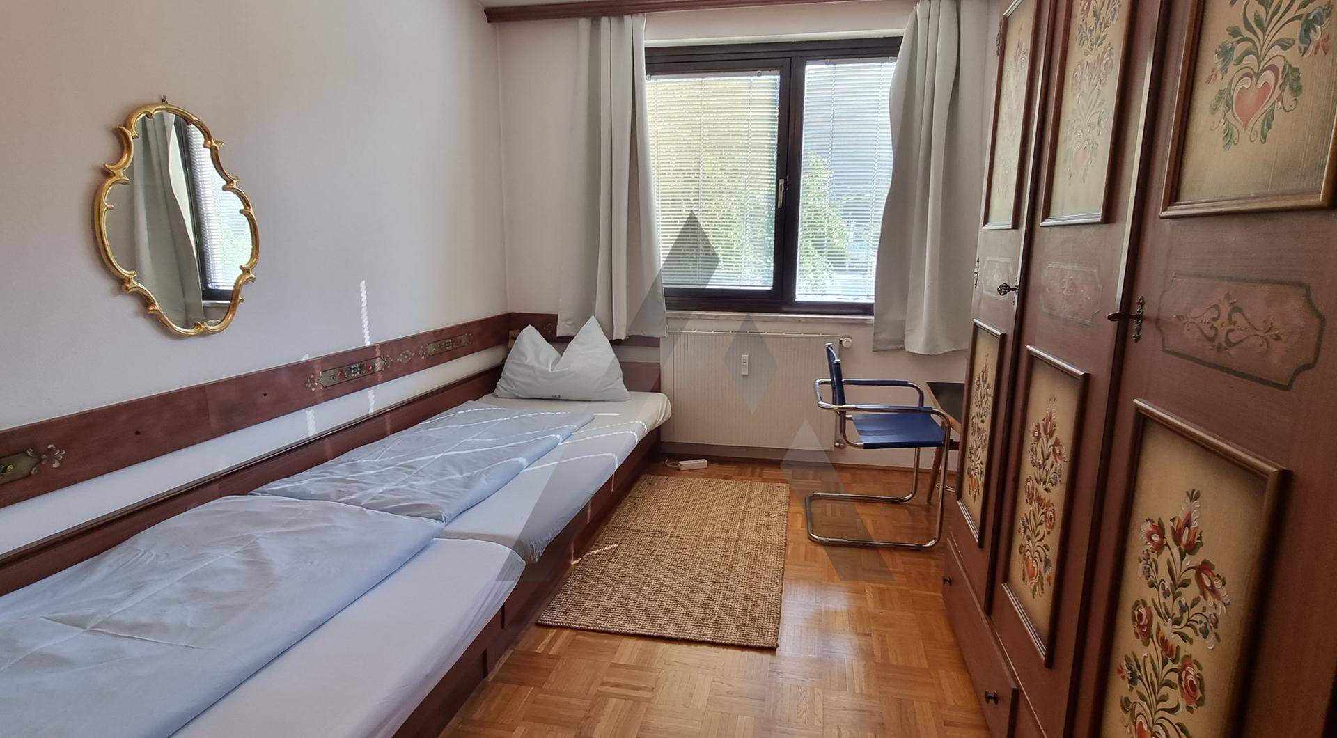 Schlafzimmer mit Einzelbetten, traditionellem Schrank und einem Fenster für Tageslicht