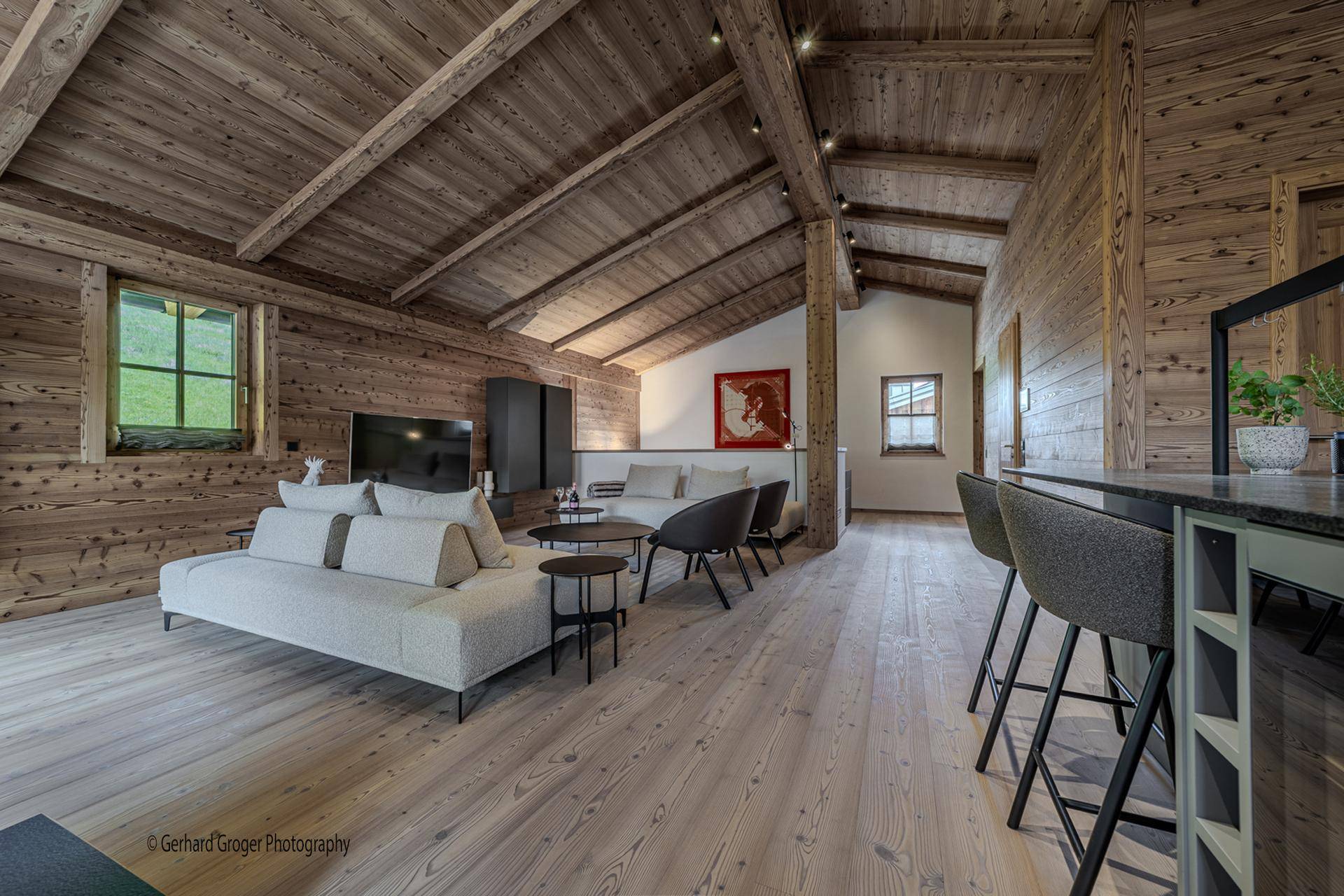 Moderne Küche mit dunklen Arbeitsplatten, integrierten Geräten und Holzboden.