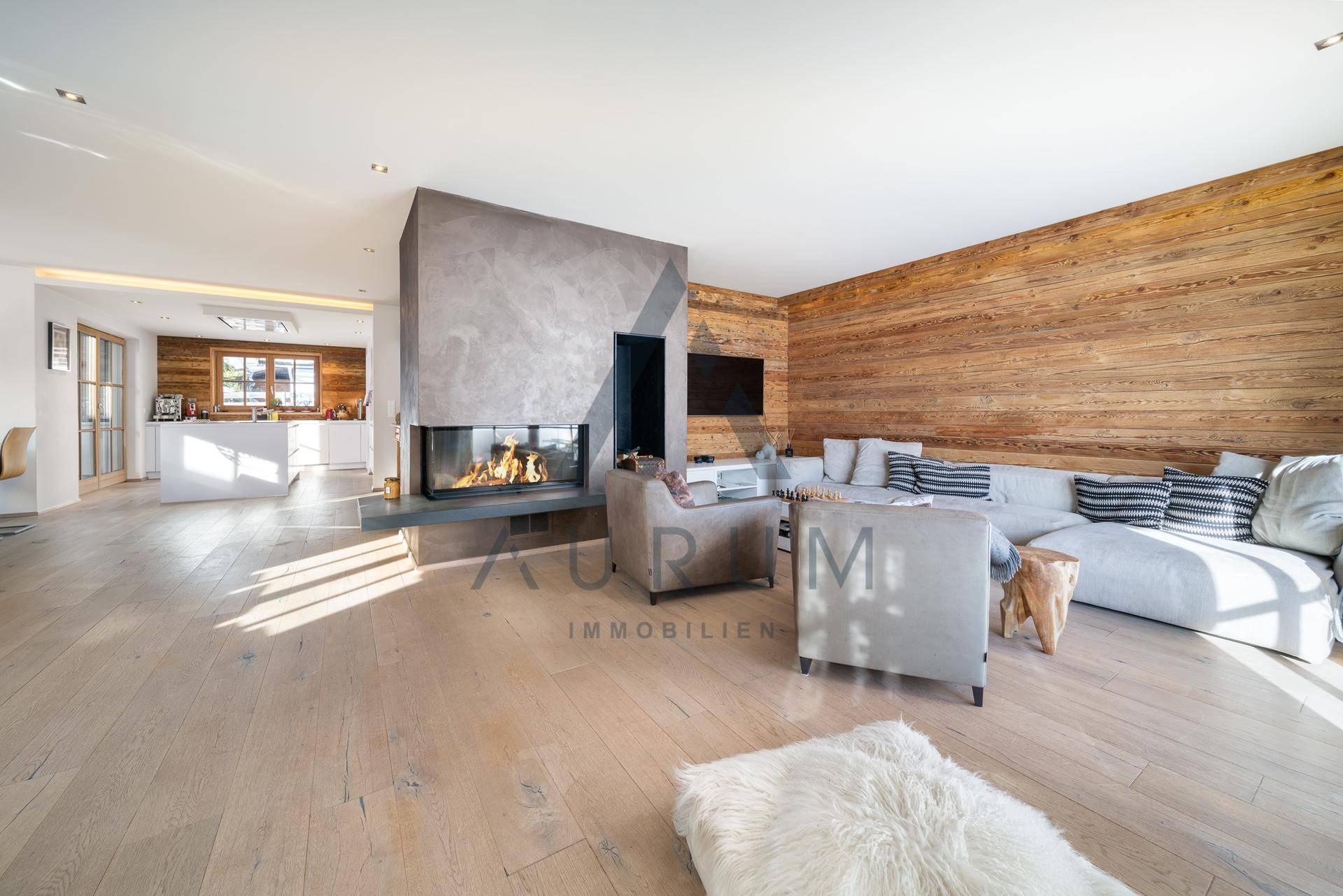 Heller Wohnbereich mit großem Kamin, Holzboden und bequemen Sofas.