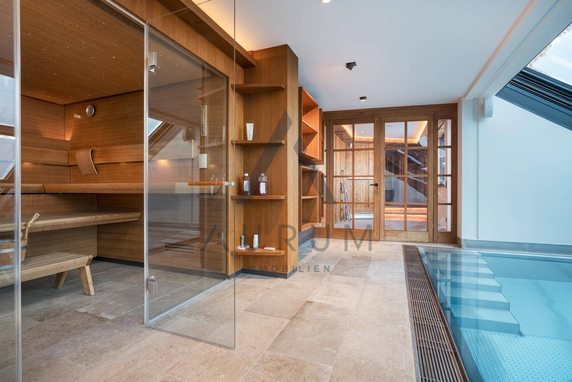 Exklusiver Wellnessbereich mit Sauna, Innenpool und großen Fenstern für viel Tageslicht.