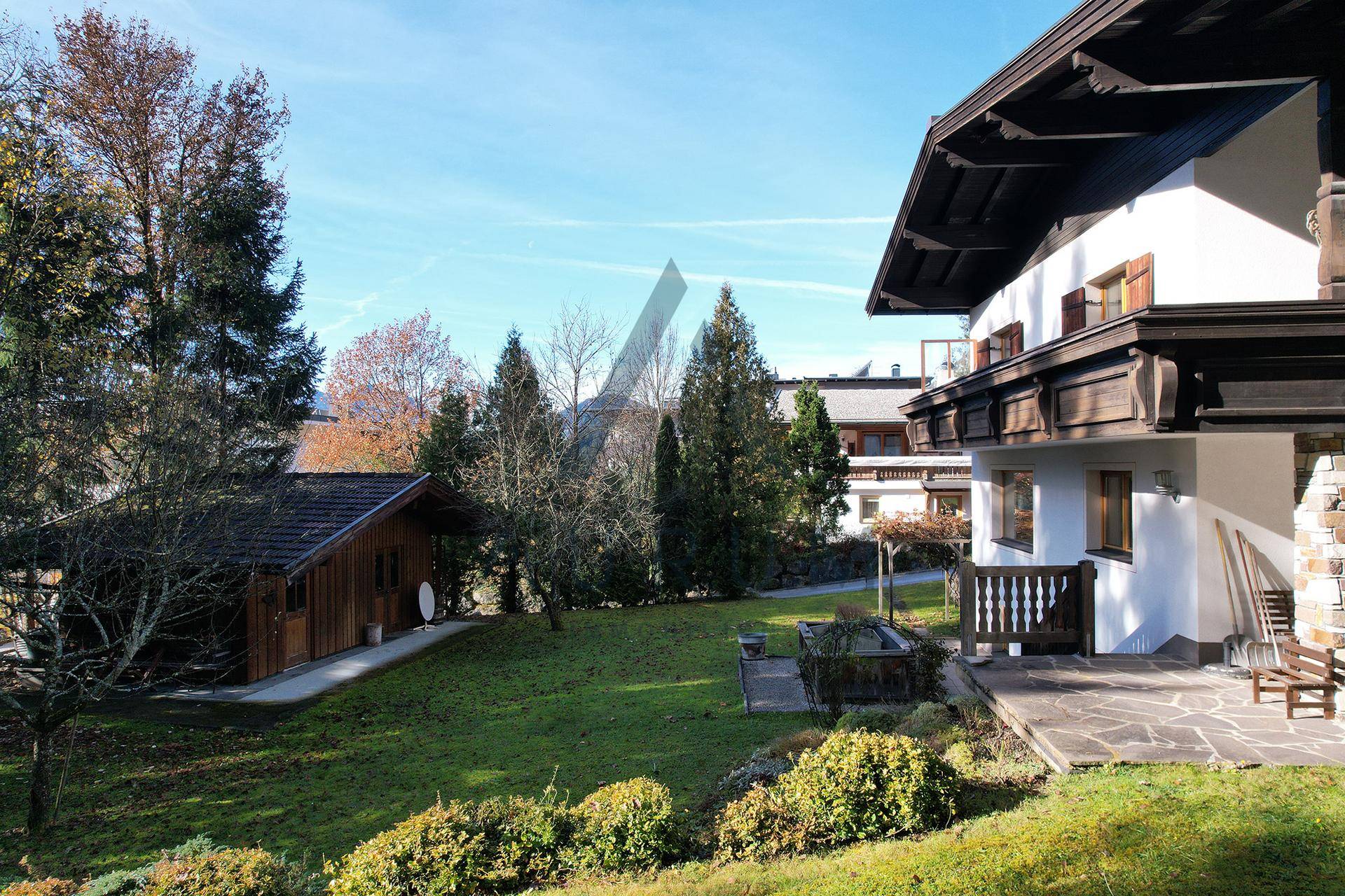Großer grüner Garten mit Rasenfläche, Bäumen und einem kleinen Gartenhaus.