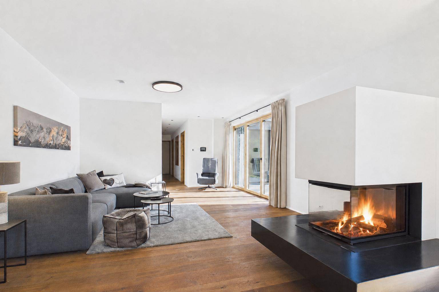 Geräumiges Wohnzimmer mit gemütlichem Kamin, bequemer Couch und Zugang zur Terrasse oder Garten.
