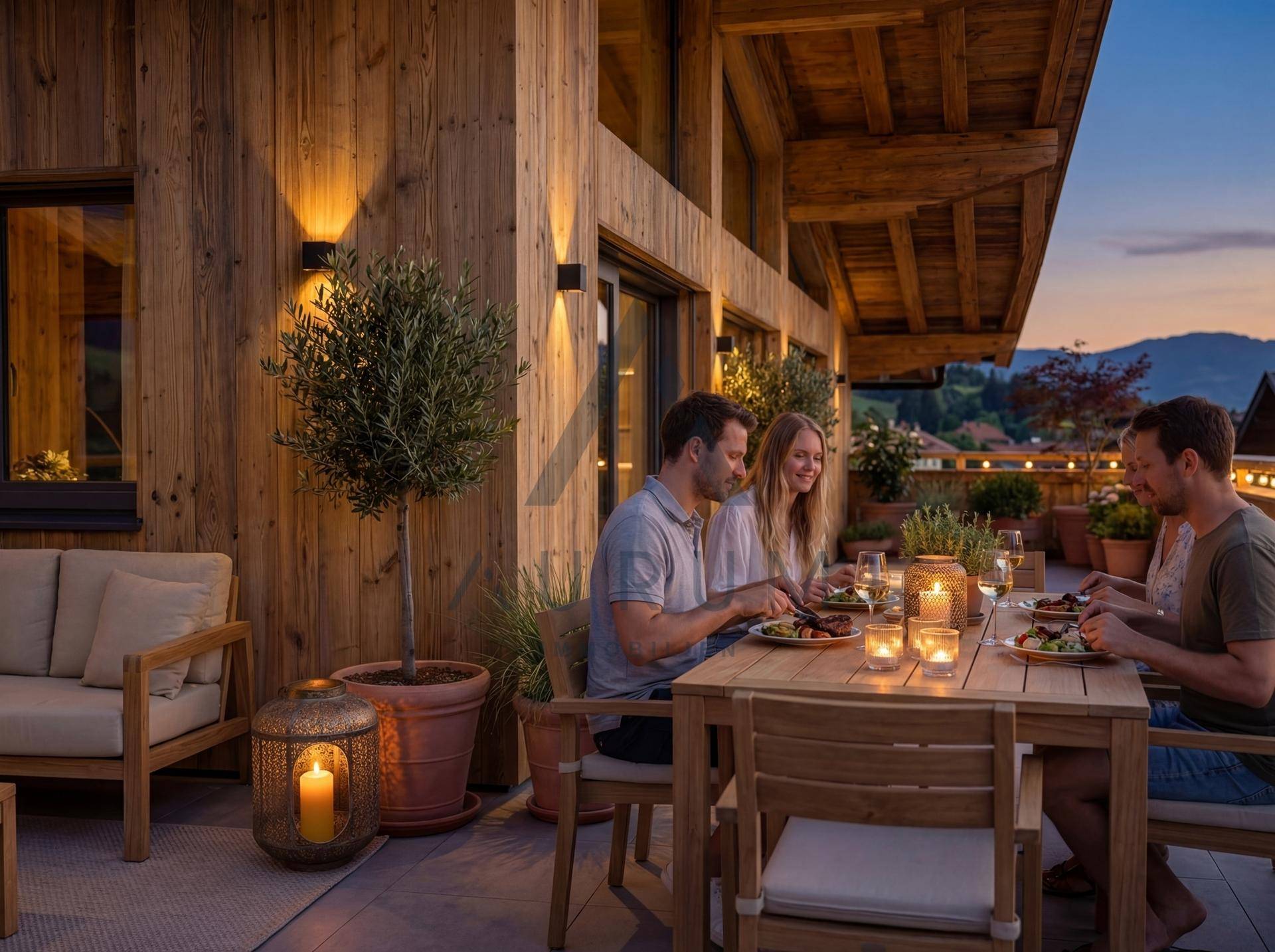 Abendliche Atmosphäre auf der Dachterrasse mit Freunden beim Essen und stimmungsvoller Beleuchtung.